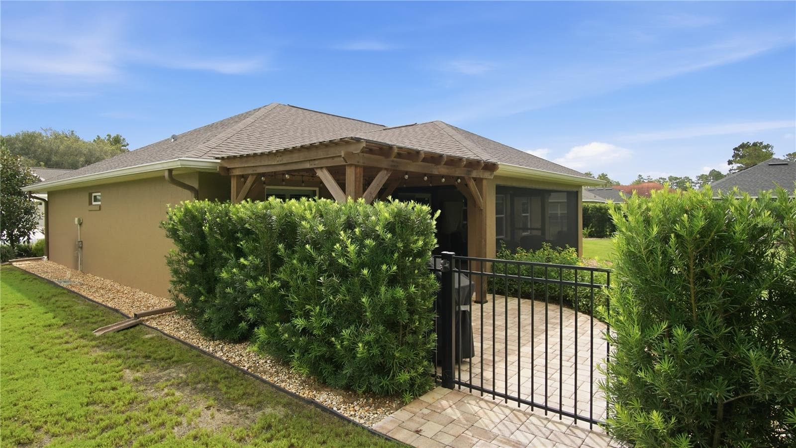 Side back gate leading to paver walkway and private shaded seating area beyond the gated backyard - 6752 SW 179TH COURT RD, DUNNELLON