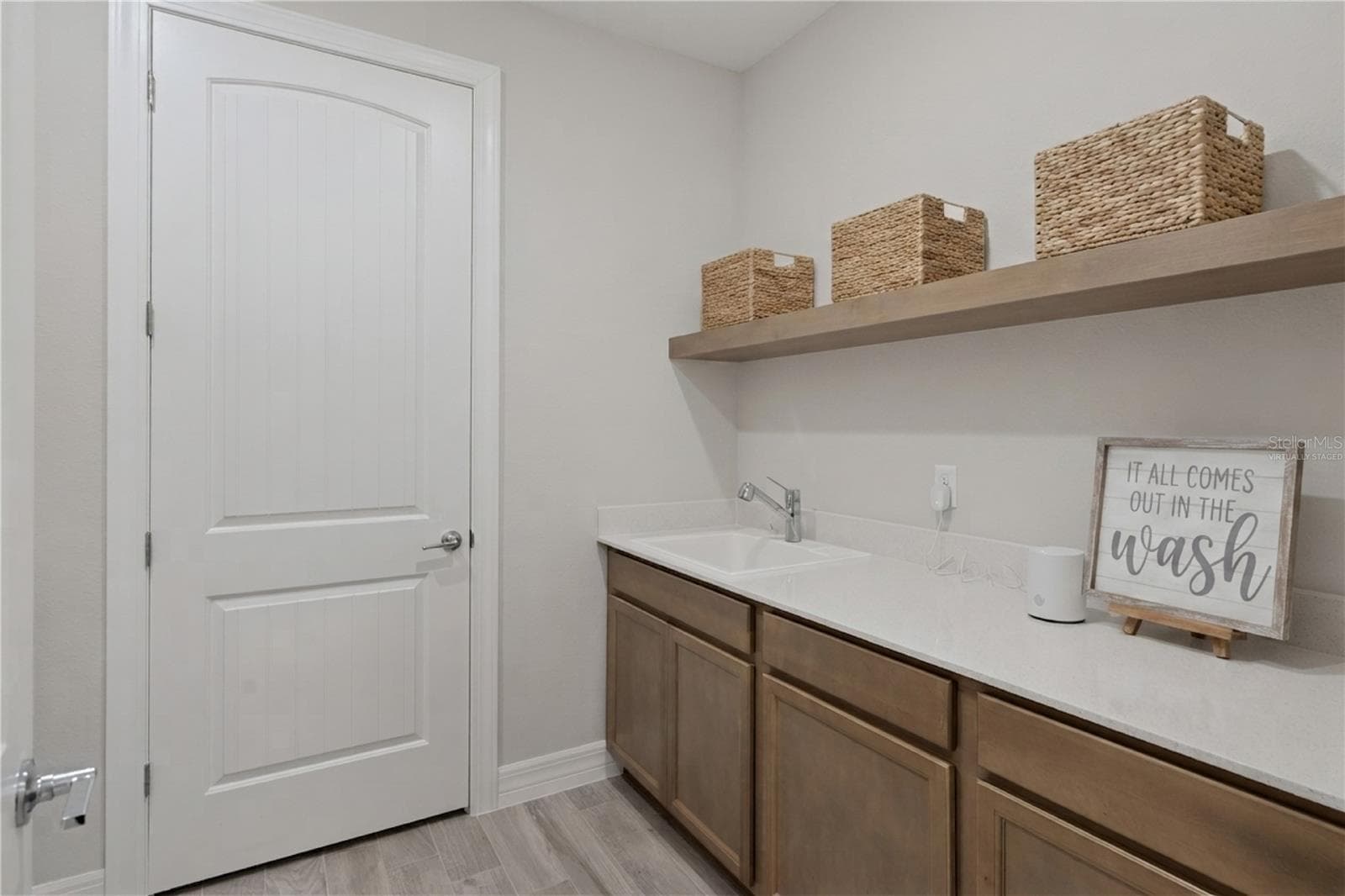 Laundry Room Virtually Staged with shelf - 2546 DEL WEBB DR, MINNEOLA