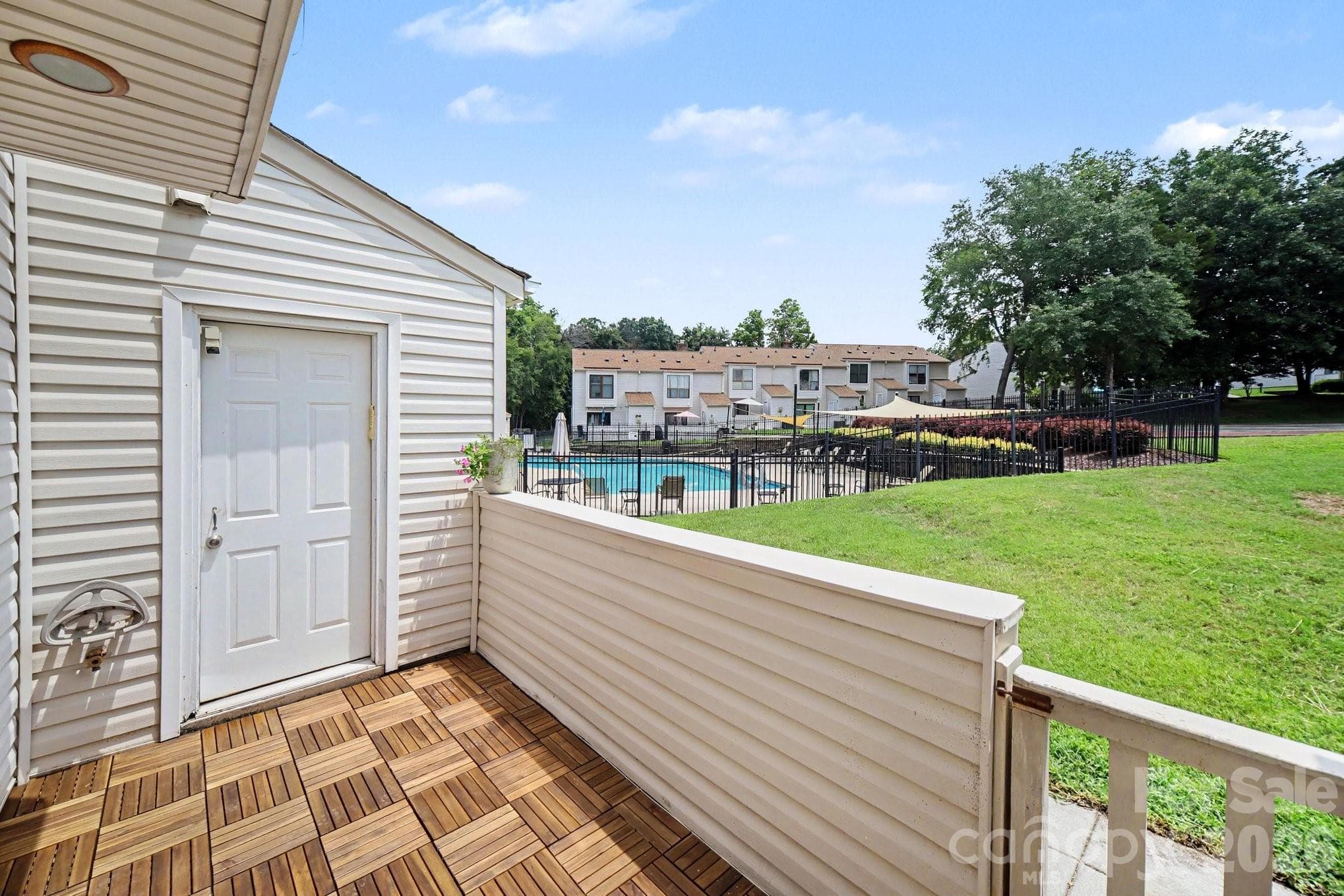 Back porch with gate, pool view and common area beyond - 11009 Carmel Crossing Road, Charlotte