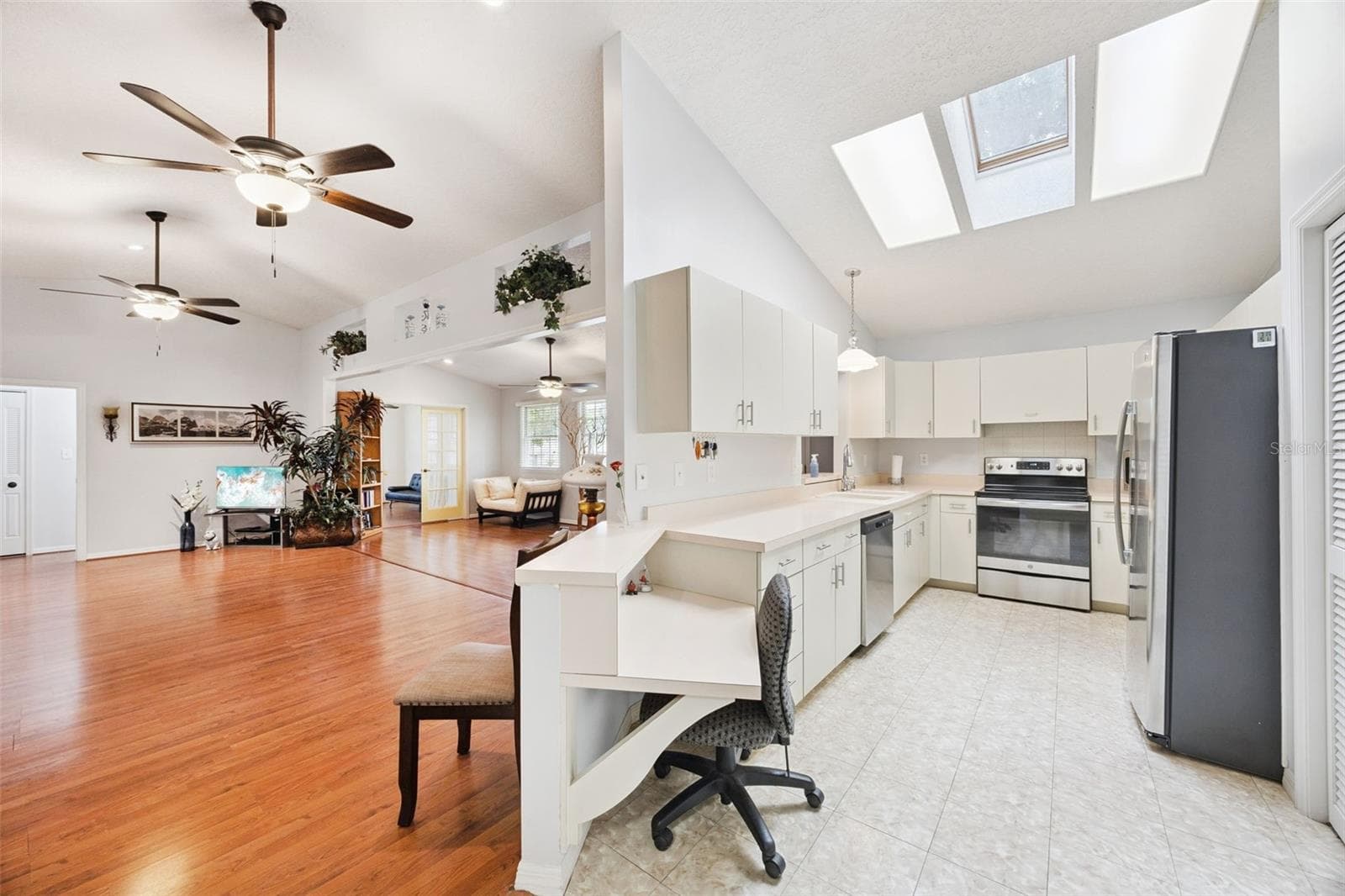 Kitchen (19x9) with skylights, white cabinetry, built-in desk, closet pantry, and all appliances included at 480 Lake Forest Cir, Mount Dora, FL 32757 - 480 LAKE FOREST CIR, MOUNT DORA
