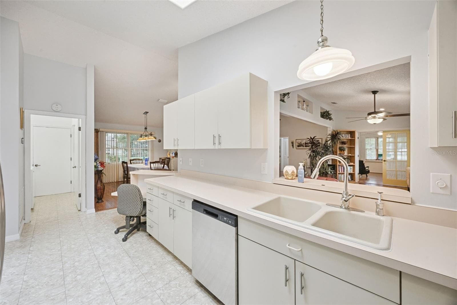 Kitchen with pass-through counter to the family room, double sink, dishwasher, range, microwave, and refrigerator, all conveying with this $380,900 Mount Dora home - 480 LAKE FOREST CIR, MOUNT DORA