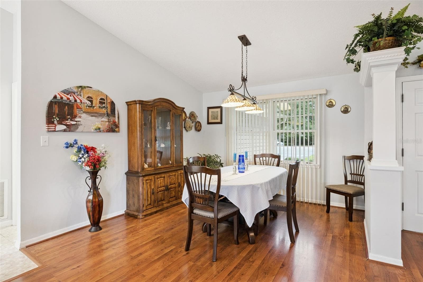 Formal dining room (13x12) with wrought iron chandelier and sliding doors to the backyard at this Lake Forest community home with $125/year HOA - 480 LAKE FOREST CIR, MOUNT DORA