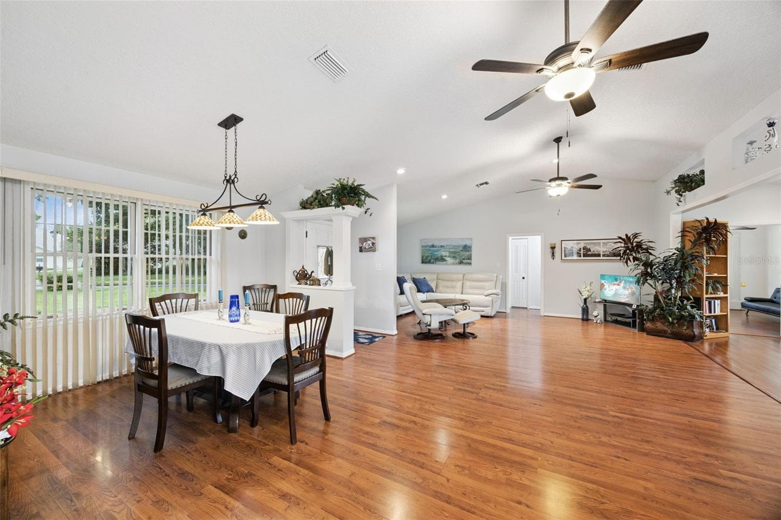 Dining area with open views to the vaulted great room and kitchen, showing the connected flow of this 1,909 sq ft split-plan layout - 480 LAKE FOREST CIR, MOUNT DORA