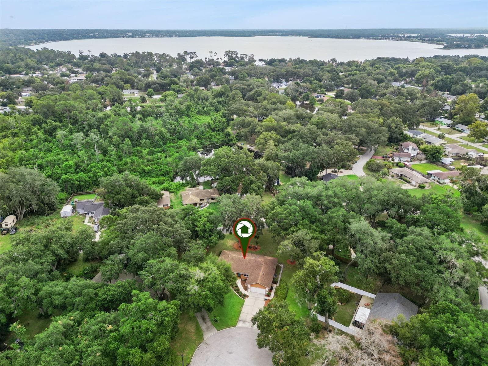 Aerial of Lake Forest showing proximity to Lake Dora and the surrounding tree-lined neighborhood at 480 Lake Forest Cir, Mount Dora, FL 32757 - 480 LAKE FOREST CIR, MOUNT DORA