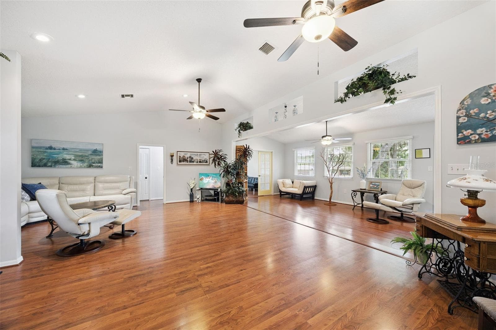 Great room alternate angle showing multiple ceiling fans, recessed lighting, and the open 1,909 sq ft layout at 480 Lake Forest Cir - 480 LAKE FOREST CIR, MOUNT DORA