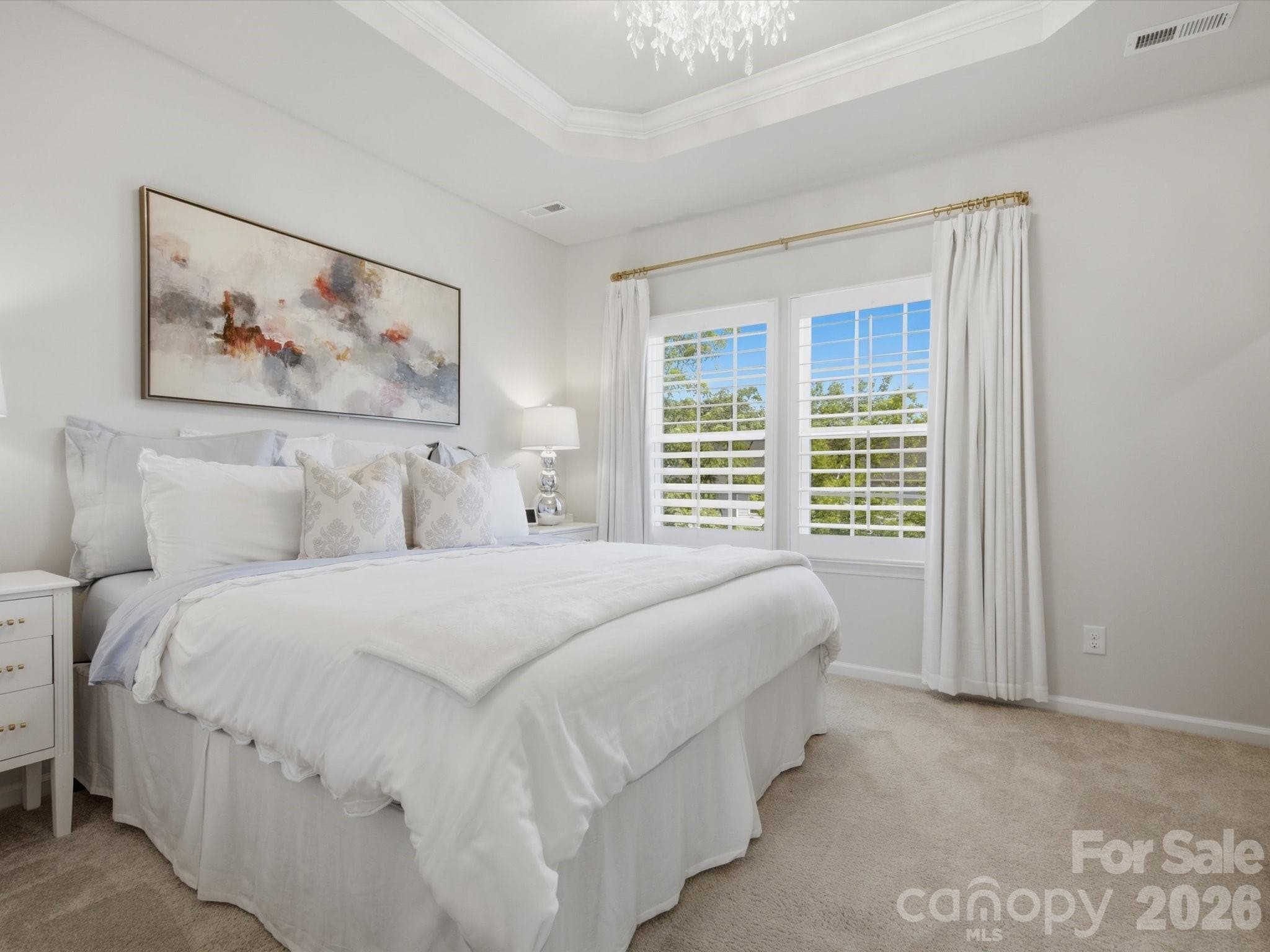 Primary with tray ceiling, crown molding, custom shutters and modern chandelier. - 4014 Edenborn Lane, Charlotte