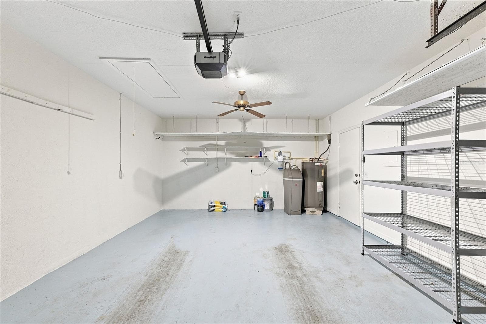 This 1.5 garage is spacious and has shelving ready for the new owner, along with bright lights and a ceiling fan for comfort. - 1124 GOLFVIEW WOODS DR #na, SUN CITY CENTER