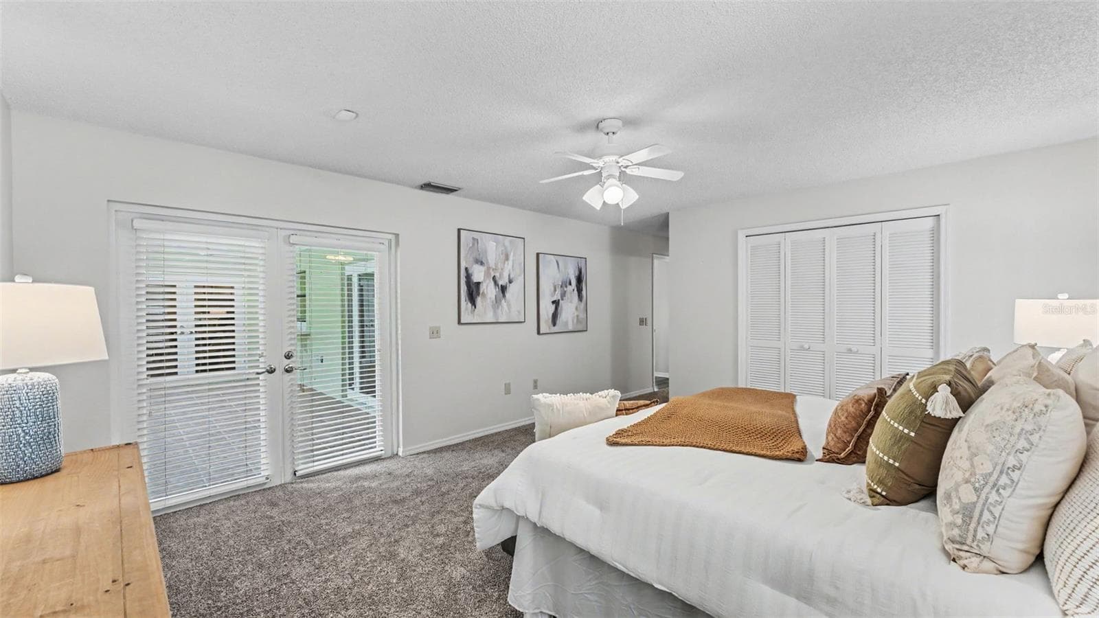 Primary bedroom suite with French doors to the covered screened patio - 4765 HIGHLANDS PLACE CIR, LAKELAND