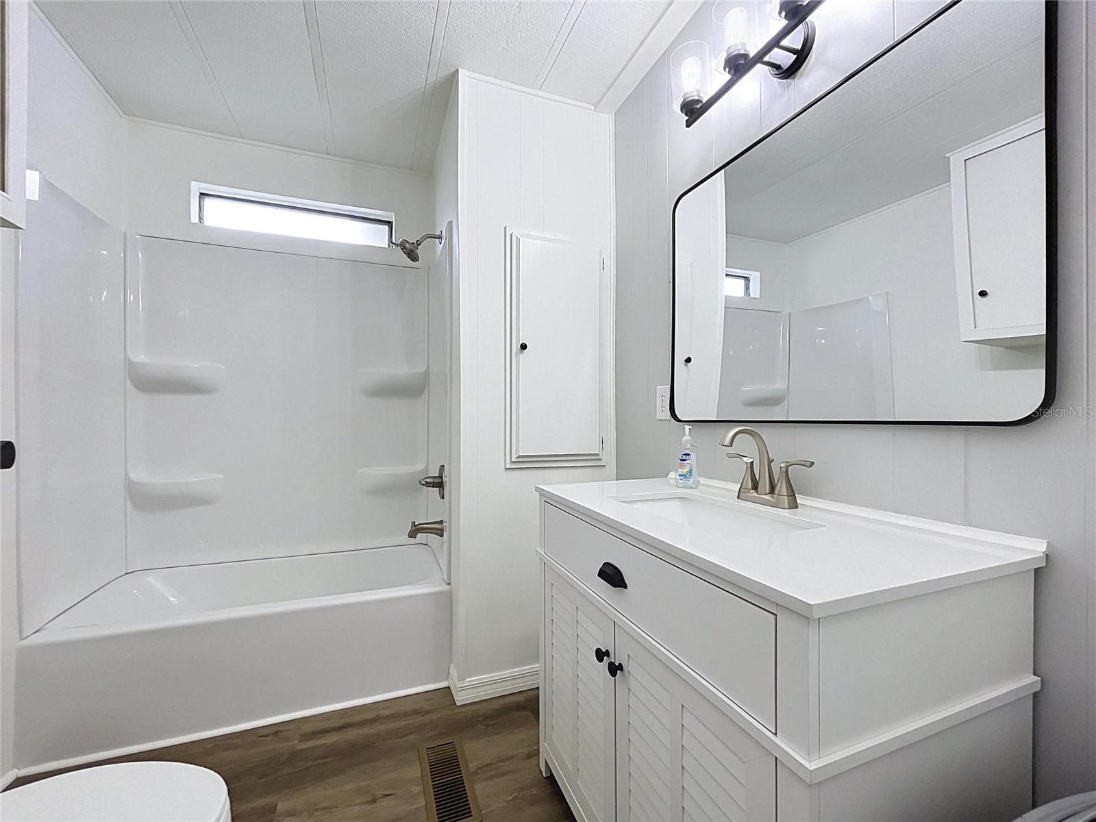 Hall Bath with new tub, surround, vanity, mirror, lights, plumbing fixtures - 6965 FORT KING RD, ZEPHYRHILLS