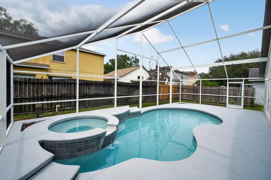 Alternate view of the screened lanai featuring the pool and spa. - 97 ABBEY HOLLOW DR, APOPKA