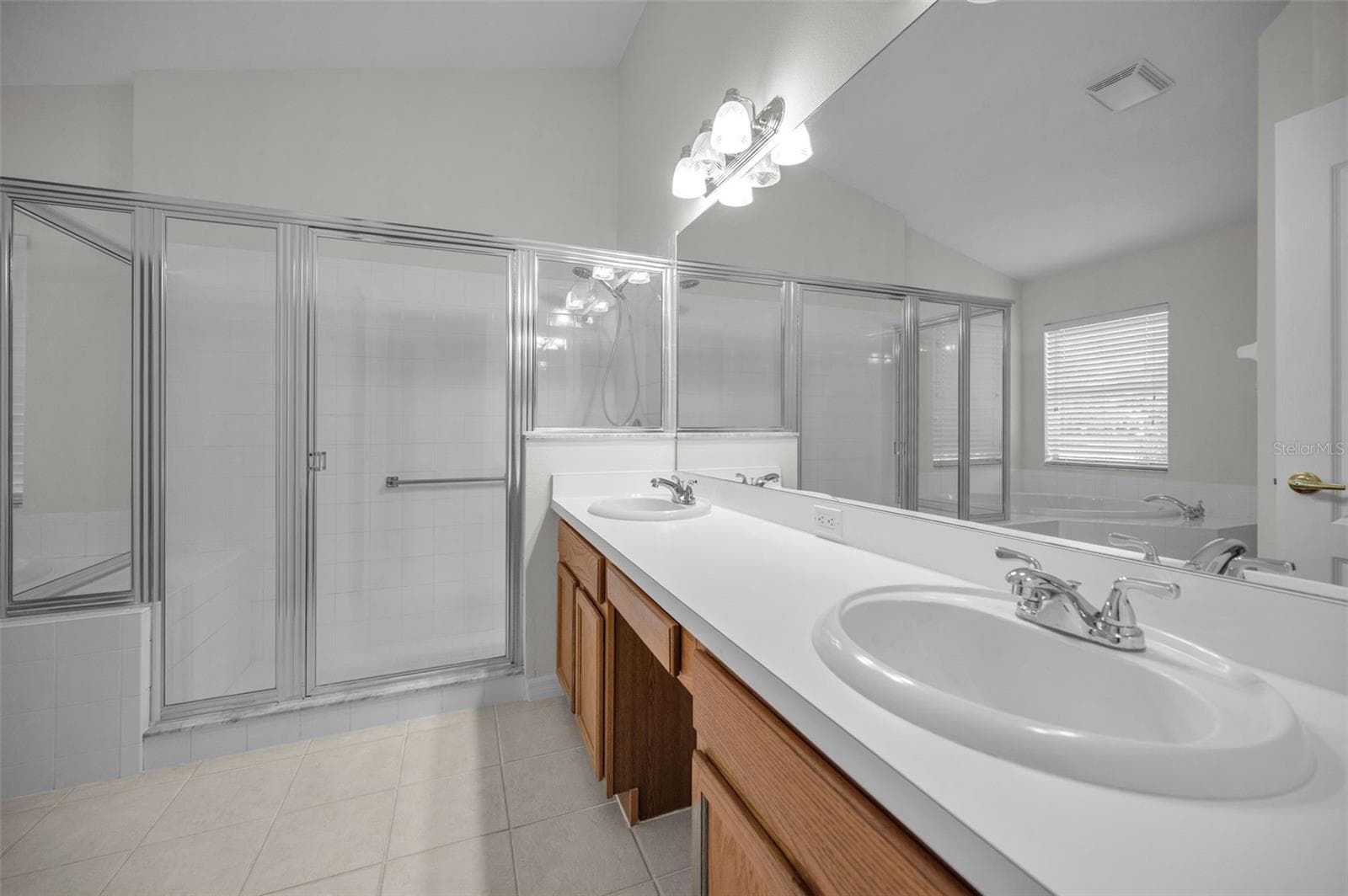 PRIMARY BATHROOM WITH WOOD CABINETS, DUAL SINKS AND LARGE WALK IN SHOWER, IT ALSO BOASTS A LARGE GARDEN TUB. - 12021 FERN TERRACE CT, TRINITY