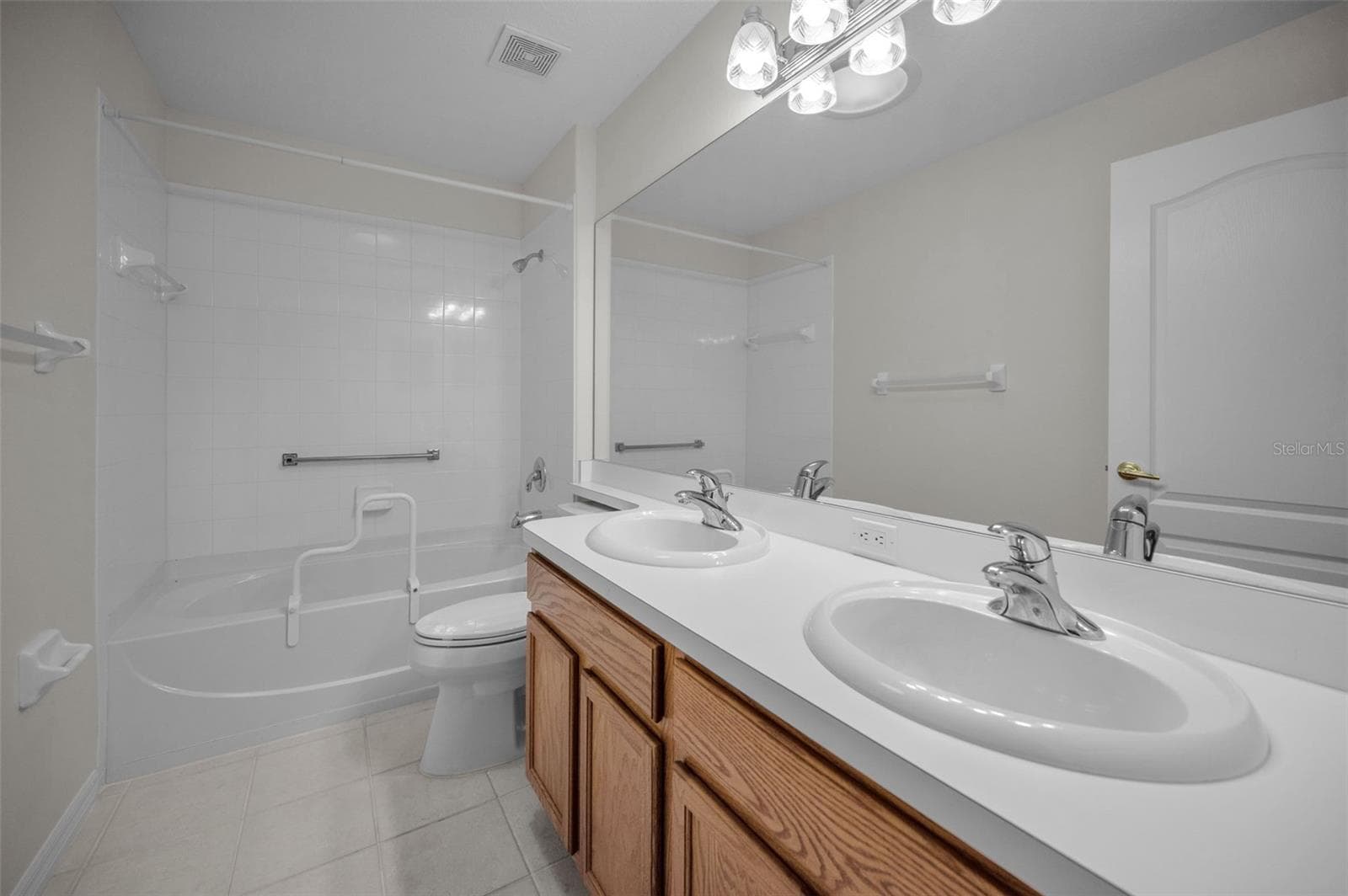 GUEST BATHROOM WITH DUAL SINKS AND TUB/SHOWER COMBO. - 12021 FERN TERRACE CT, TRINITY