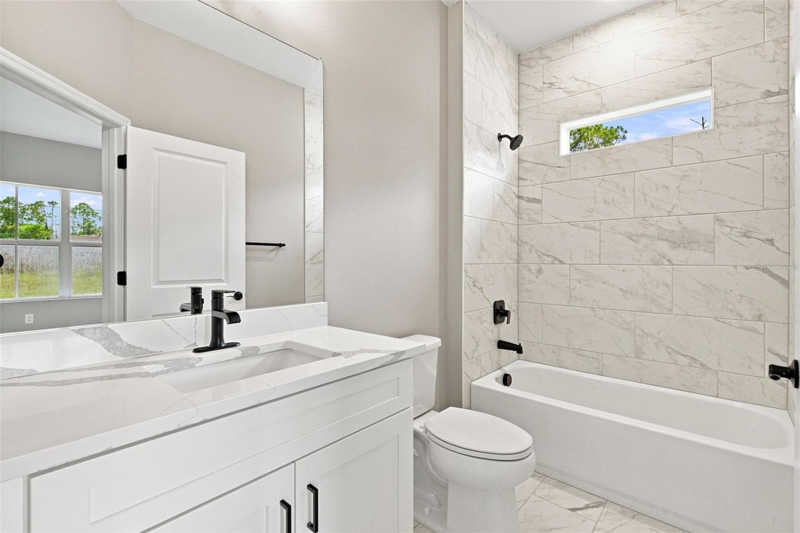 Full bathroom shared between bedrooms 3 and 4. - 8211 ELKENBERRY AVE, NORTH PORT