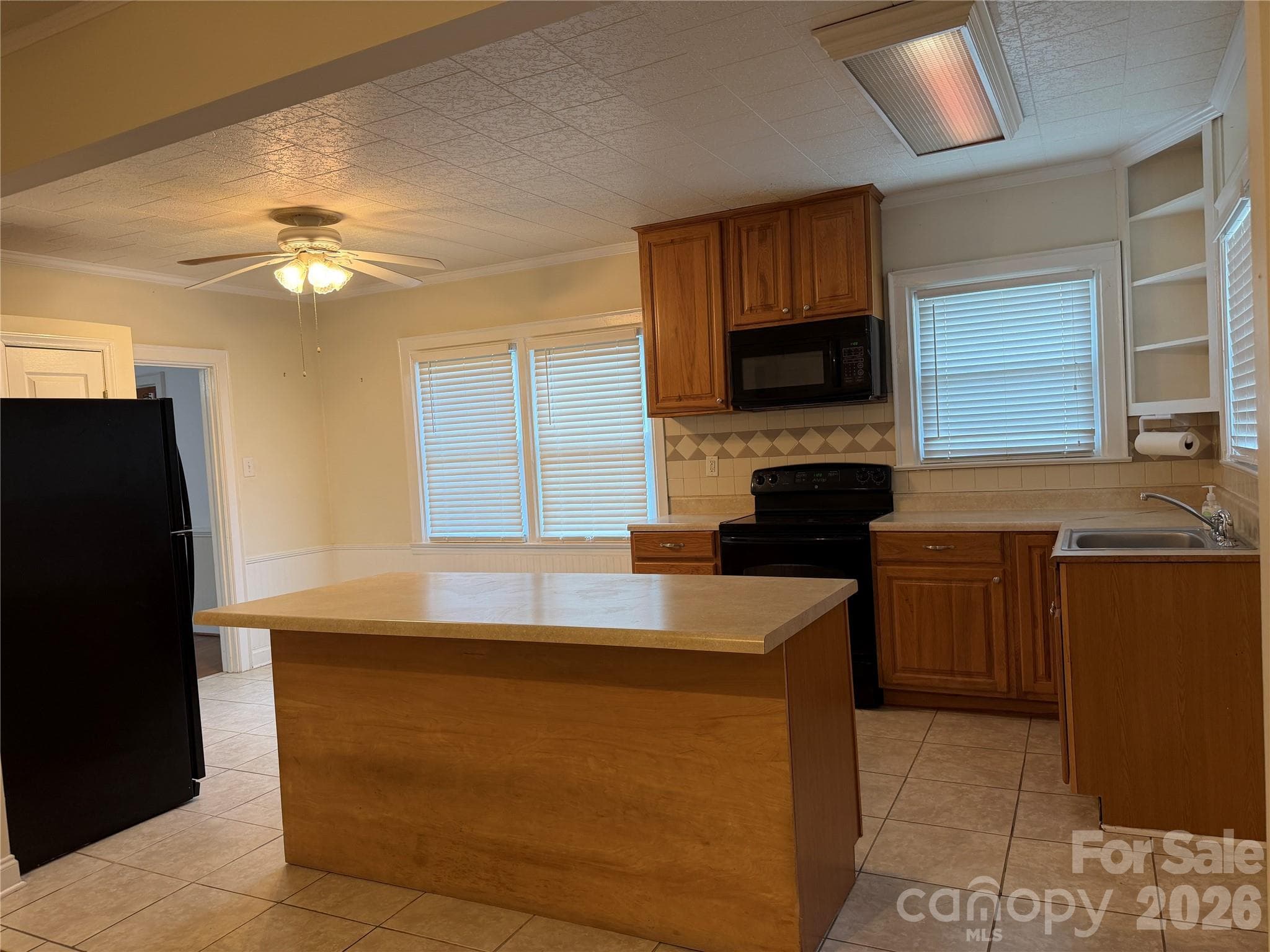 Well-appointed kitchen with newer appliances, tile flooring, and a tile backsplash. A center island provides additional storage and prep space. - 612 Ballard Street, Chester