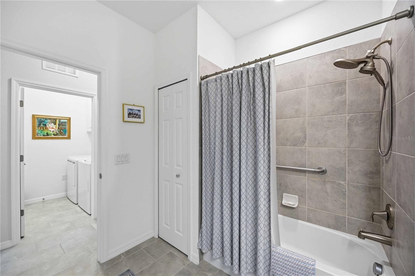 The guest bath has tub/shower combination and a linen closet - 10821 TARFLOWER DR #202, VENICE