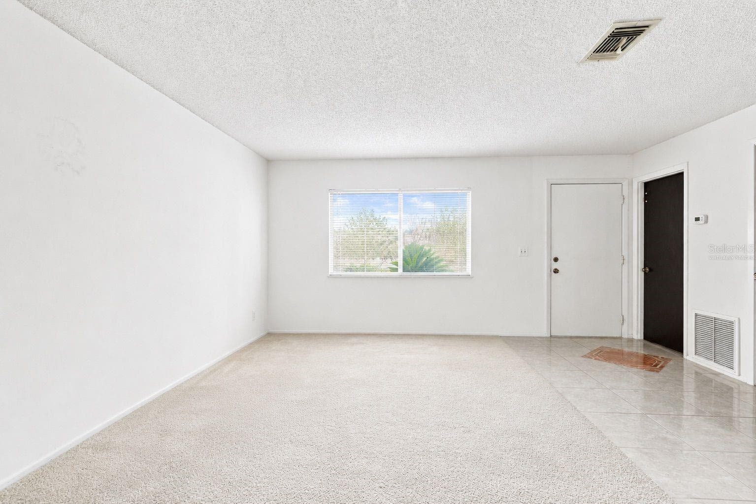 Virtually staged living room and entry - 1418 CATALINA BLVD, DELTONA
