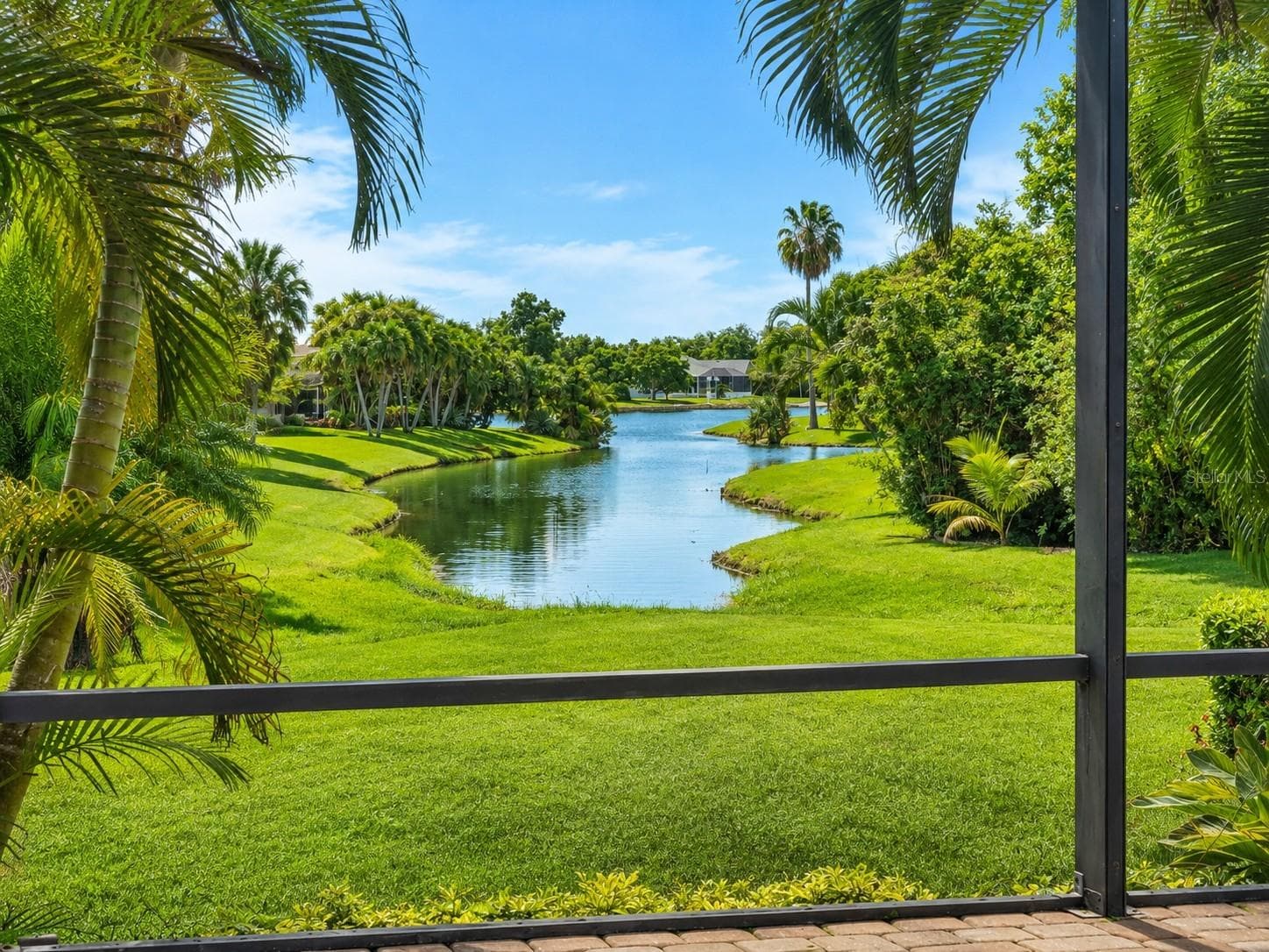 Peaceful tropical water views framed by lush palms and beautifully maintained landscaping - 24228 PEPPERCORN RD, PUNTA GORDA