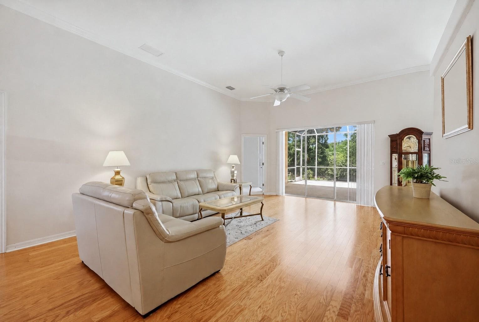Bright living room with hardwood floors, large windows and seamless connection to outdoor living - 8492 IDLEWOOD CT, LAKEWOOD RANCH