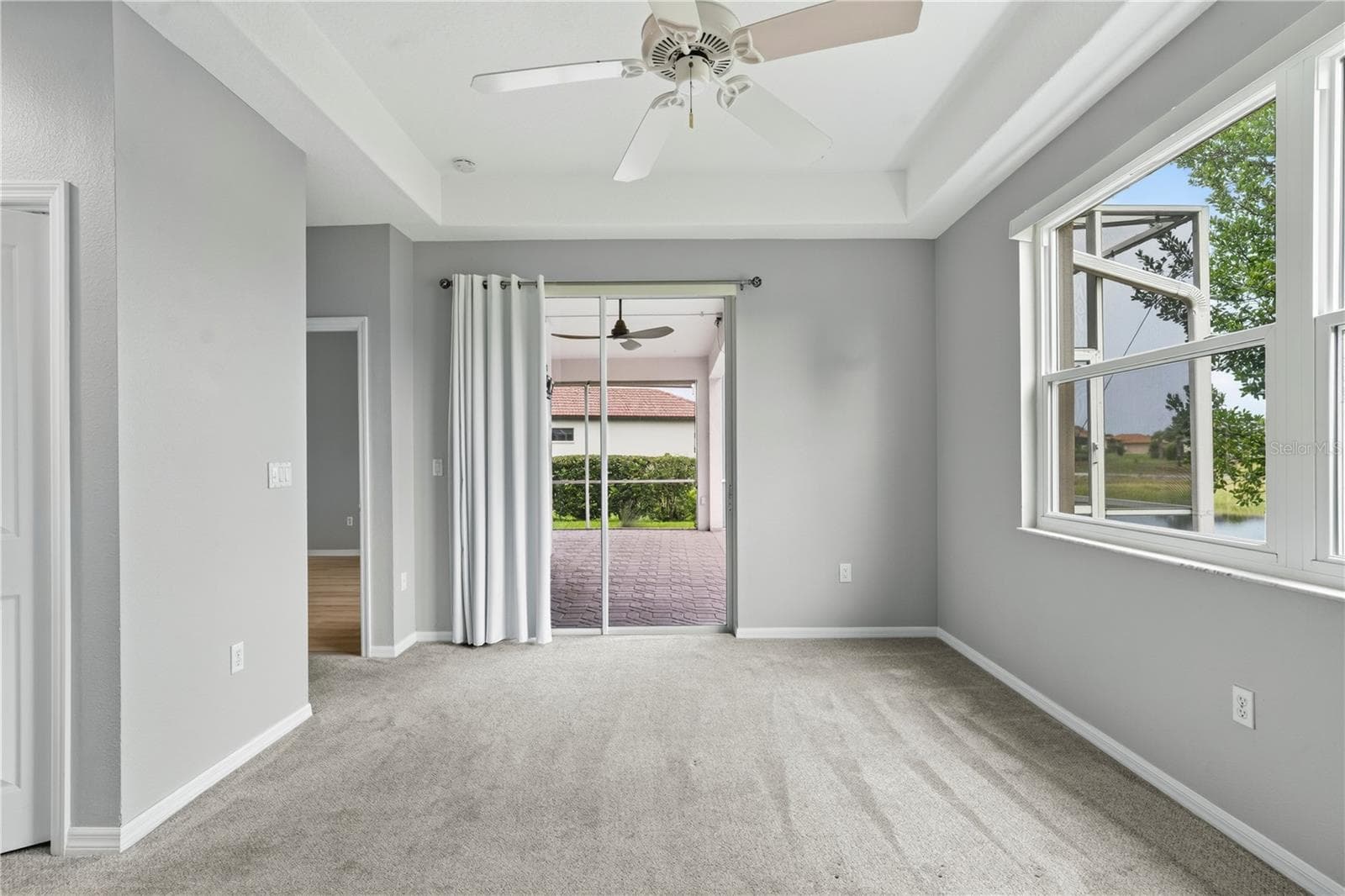 Primary bedroom w/ glass sliding doors to outside enclosed screened patio/lanai - 9257 BONNIE COVE DR, WEEKI WACHEE