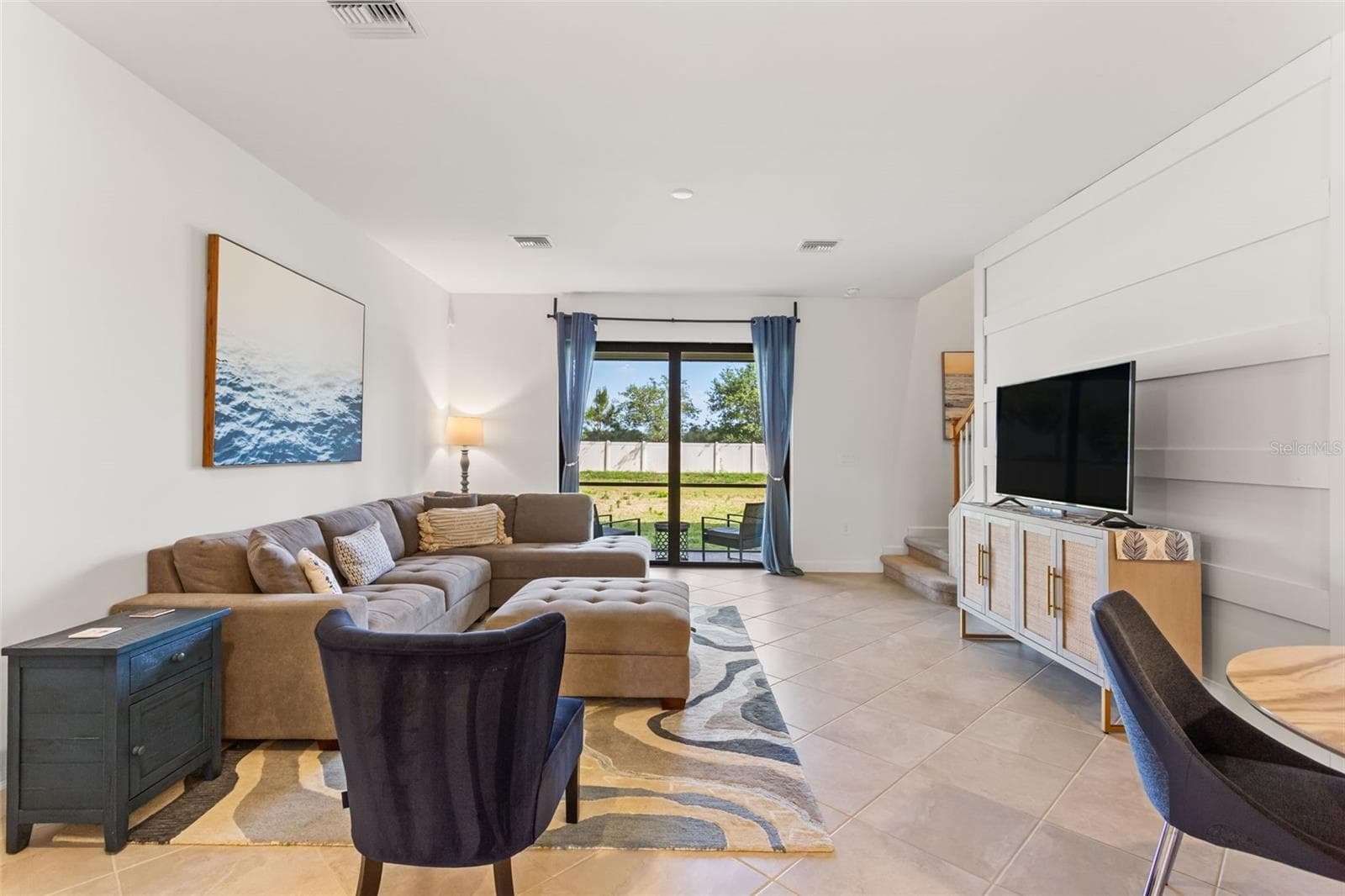 The open-concept main level is adorned with durable tile flooring and filled with natural light - 14275 PINE LODGE LN, FORT MYERS