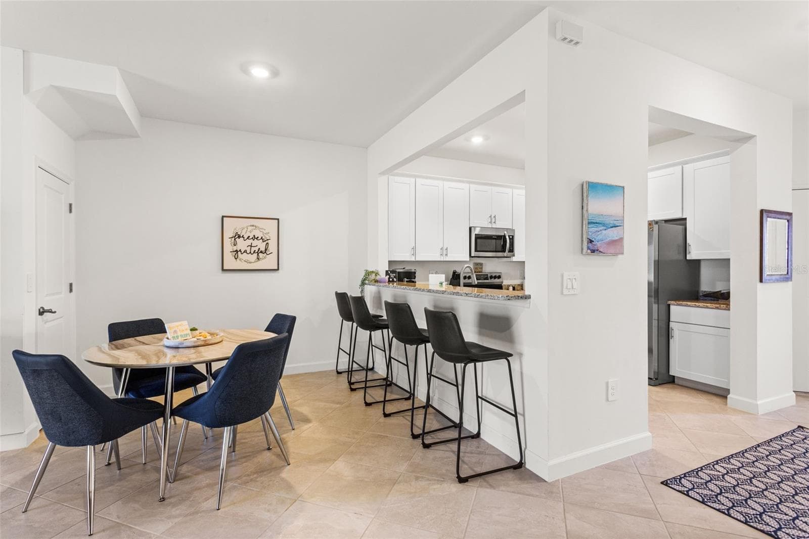 A versatile breakfast bar offers the perfect spot for casual dining or morning coffee - 14275 PINE LODGE LN, FORT MYERS