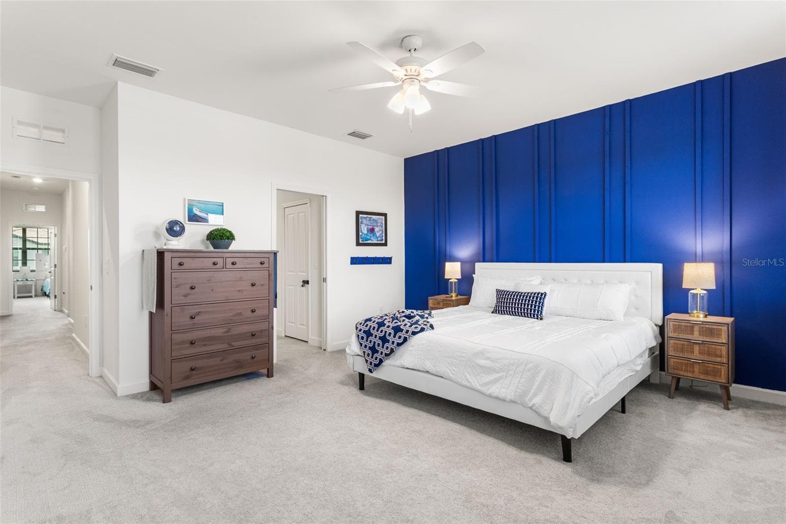 Spacious primary suite offering plenty of room to relax, highlighted by a striking designer accent wall and ceiling fan :) - 14275 PINE LODGE LN, FORT MYERS