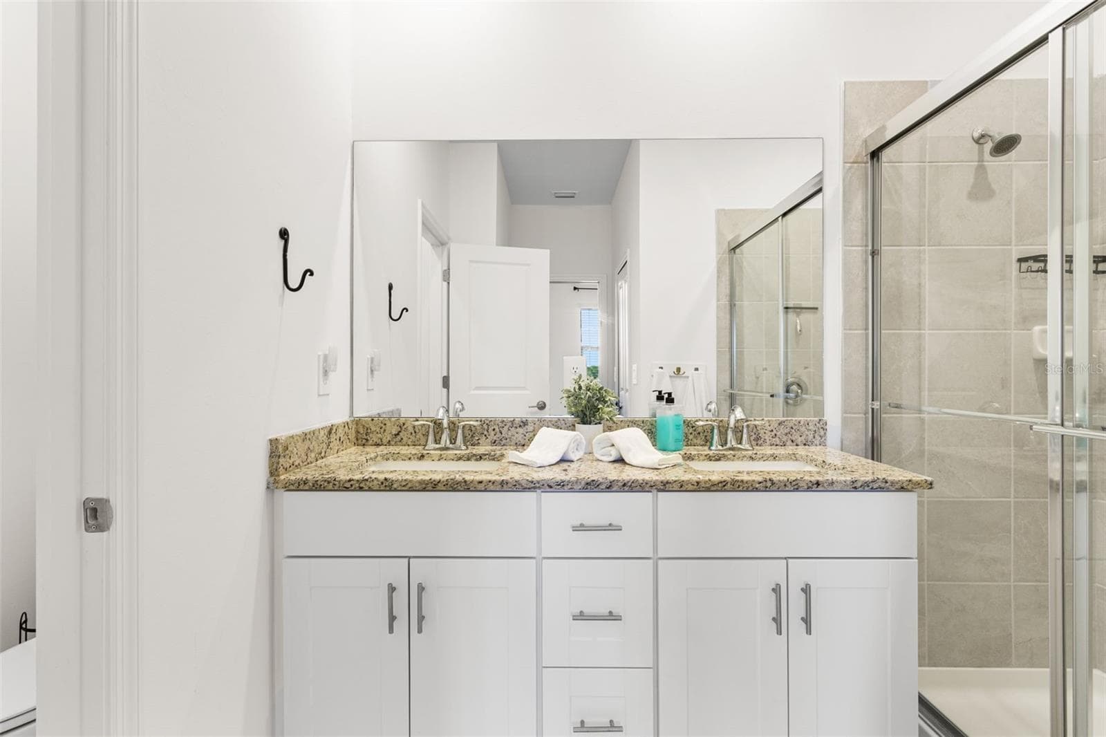 The ensuite bath offers granite countertops, dual sinks, and a glass-enclosed walk-in shower - 14275 PINE LODGE LN, FORT MYERS
