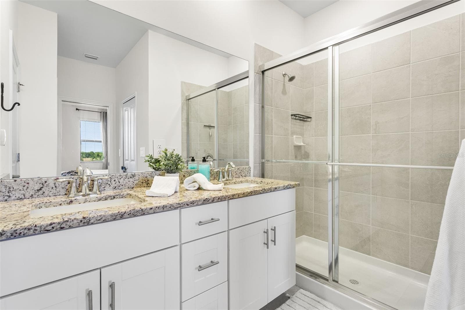 Spacious primary bathroom featuring a dual-sink granite vanity, glass-enclosed walk-in shower, and private water closet - 14275 PINE LODGE LN, FORT MYERS