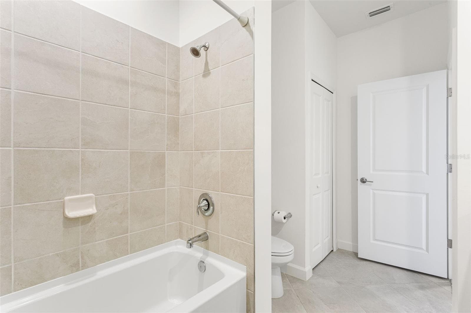 Upstairs second full bathroom featuring a tub/shower combination, ideal for family or guests - 14275 PINE LODGE LN, FORT MYERS