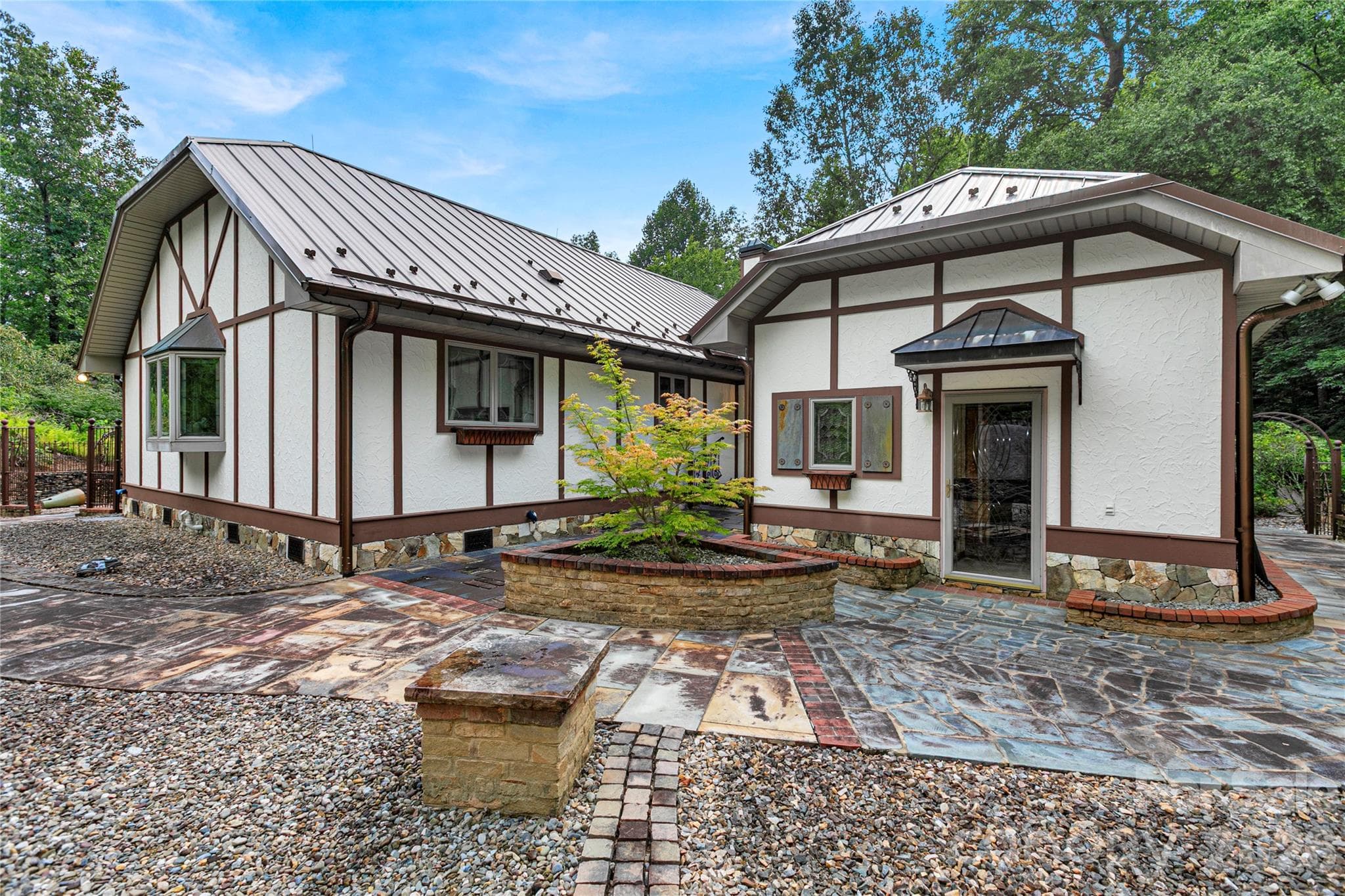 Custom iron entry gate on the right of this picture. Stone pathway leads here to the fenced back yard with more custom rock work and stone planters! Mud room door, visible here, leads into rear full bath and garage. - 275 Hubbard Hollow Road, Rosman