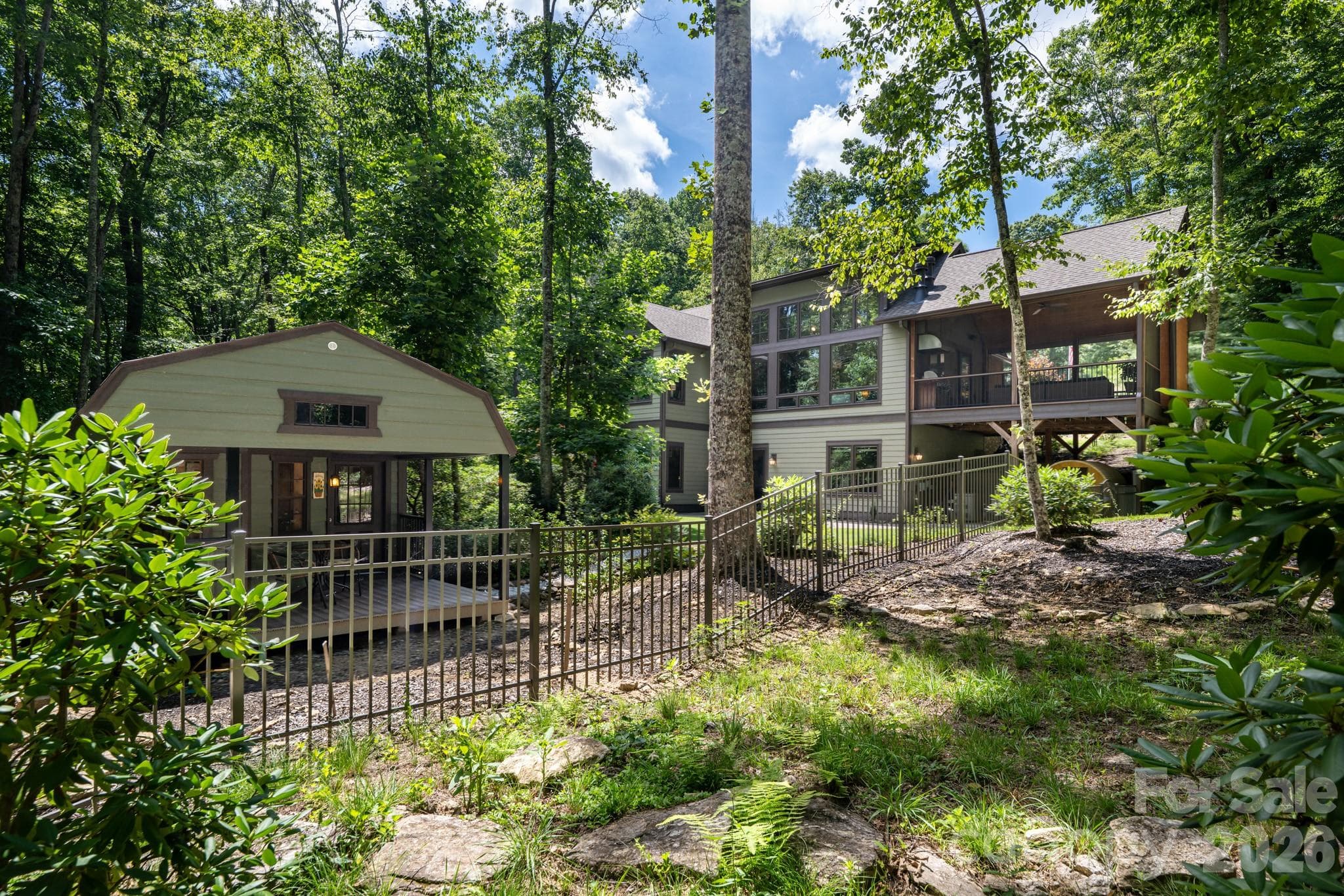 View of the property from the back, showing outbuilding and fenced yard. - 403 Thunder Mountain Road, Hendersonville