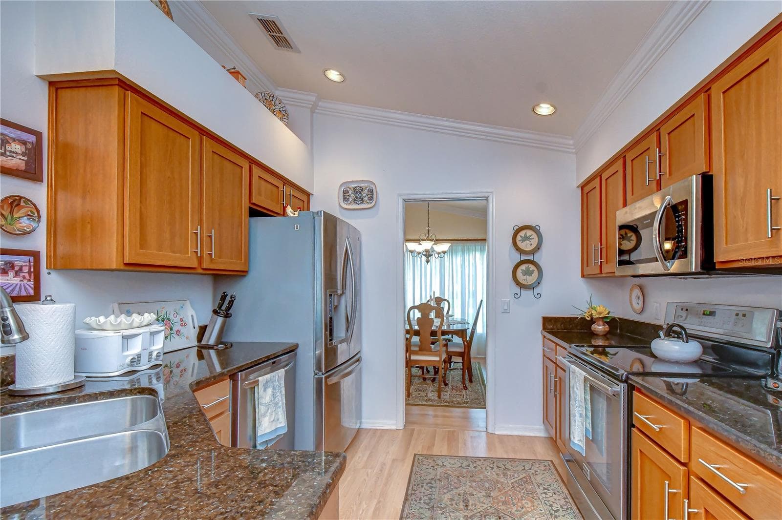 Well-appointed kitchen featuring stainless steel appliances, abundant cabinetry, and a convenient breakfast bar. - 5602 ROCKFIELD LOOP, VALRICO