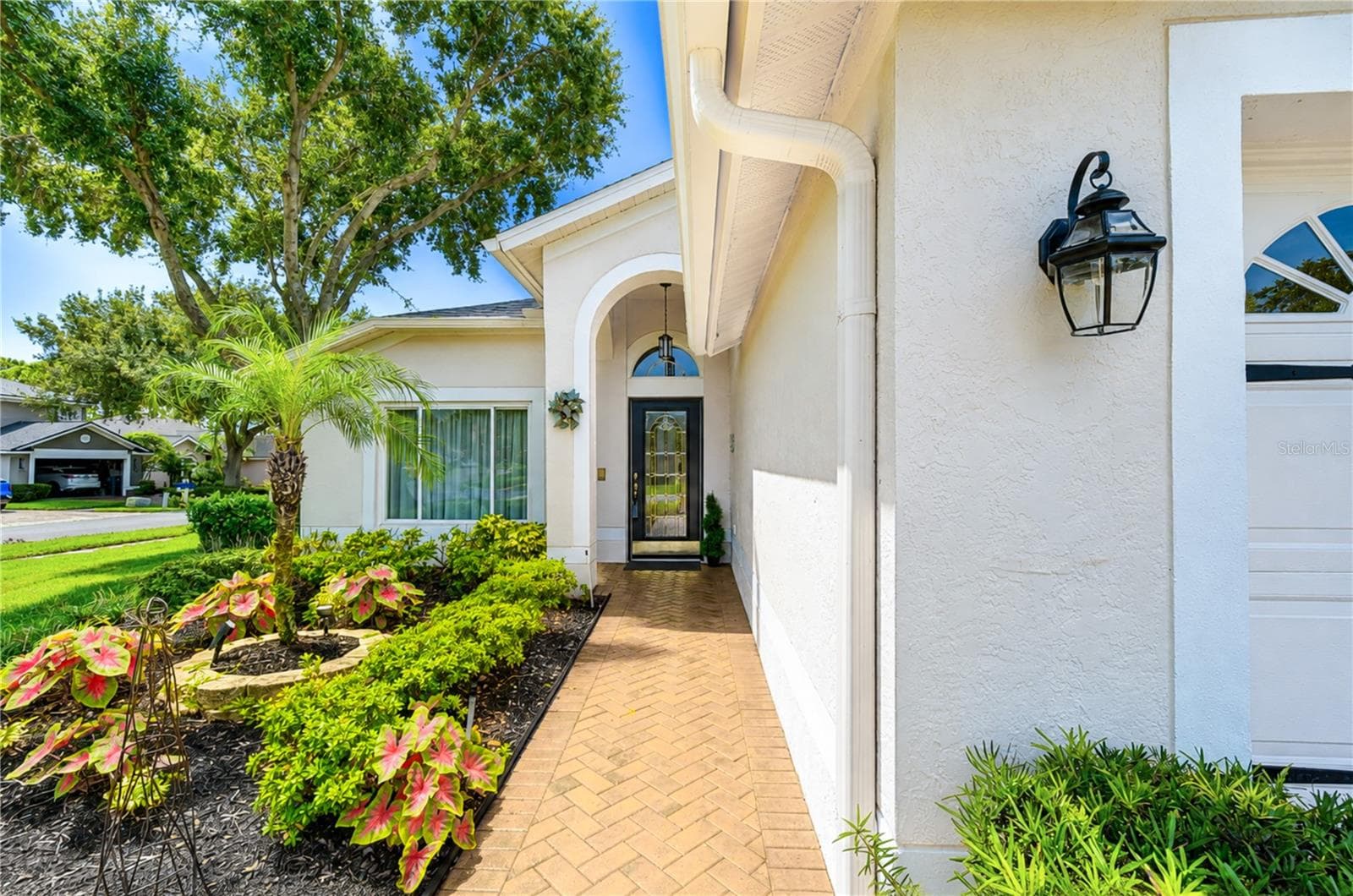 Manicured landscaping and mature greenery enhance the home's exceptional curb appeal. - 5602 ROCKFIELD LOOP, VALRICO