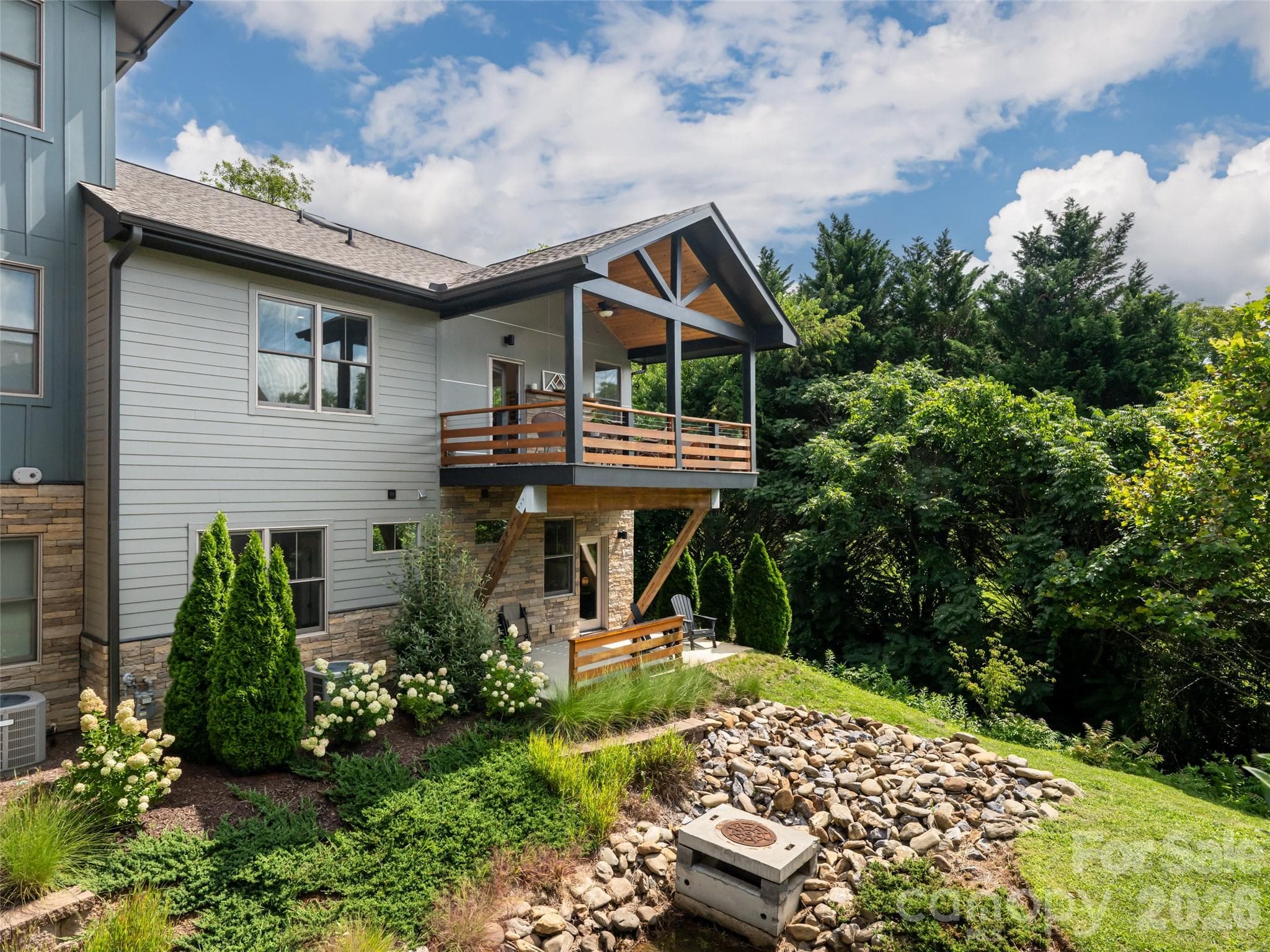 Beautiful back yard with river rock, evergreens and a forest of privacy - 309 Ava Lane, Asheville