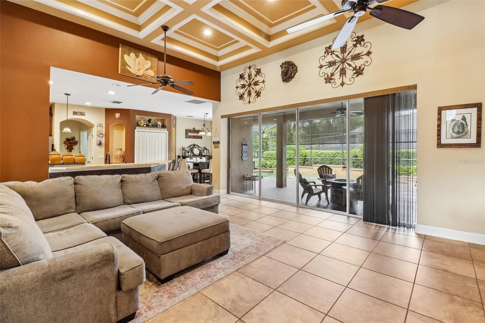 Family room is open to the kitchen with a wall of sliding glass doors that open to the lanai and pool. - 2947 CEDAR CREST DR, APOPKA
