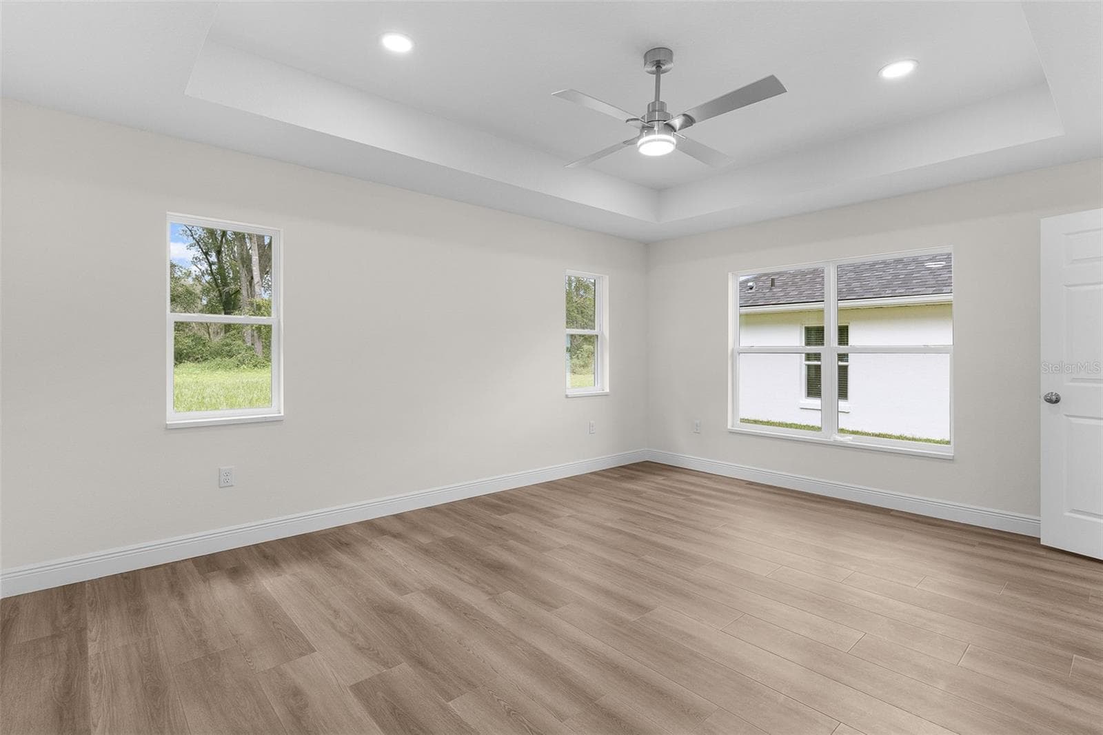 Primary Bedroom with tray ceiling, LVP Flooring, Fan, Window Blinds coming soon. - 8277 SE 158TH ST, SUMMERFIELD