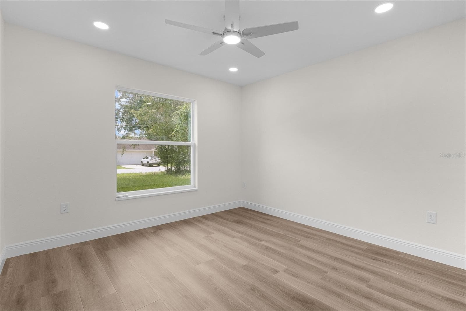 Front Guest Bedroom with LVP Flooring and ceiling fan. - 8277 SE 158TH ST, SUMMERFIELD