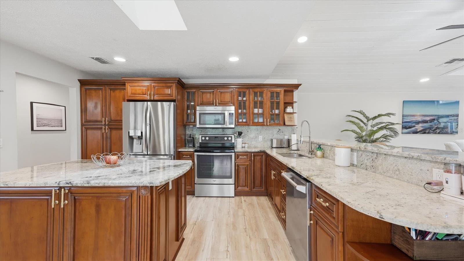 Timeless finishes including elegant granite over high quality wood cabinets featuring glass door uppers, a lazy Susan corner cabinet, hideaway garbage, decorative shelves and stainless steel appliances. - 15127 PENNINGTON RD, TAMPA