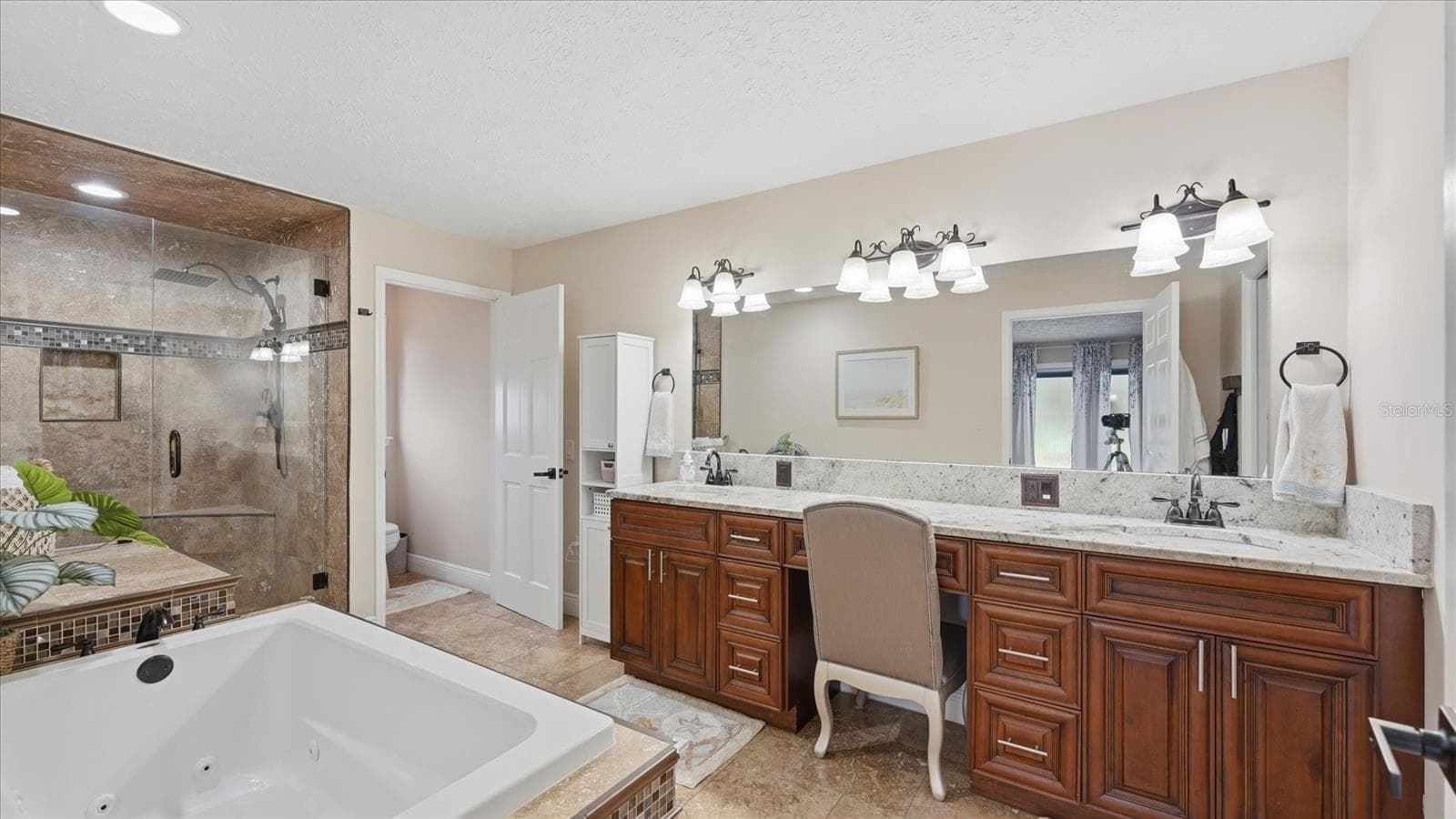 Spacious dual vanities with lots of storage and elegant granite counters.  A private water closet, shower and tub complete this ensuite bath - 15127 PENNINGTON RD, TAMPA