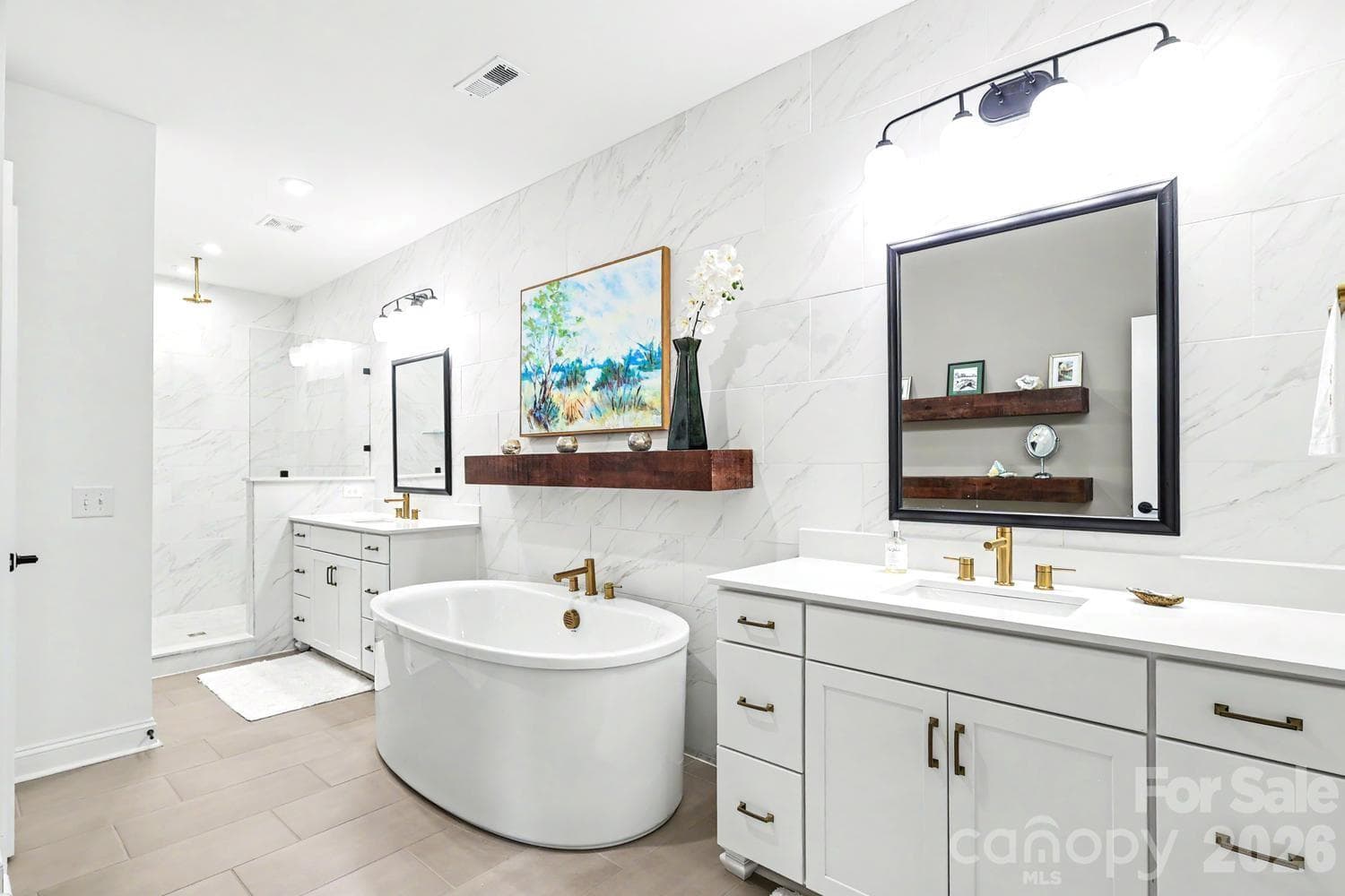 Primary bathroom featuring dual vanities, a spacious soaking tub, an elegant walk-in shower, and a private water closet. - 2505 Kenmore Avenue, Charlotte