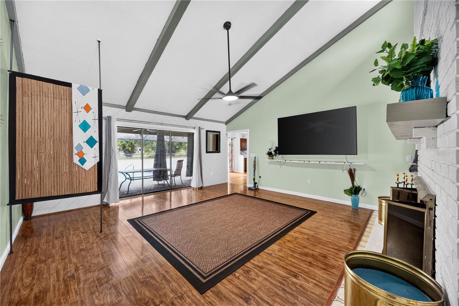 Great room with fireplace, TV and pool access. - 1305 GREENFIELD CIR, VENICE