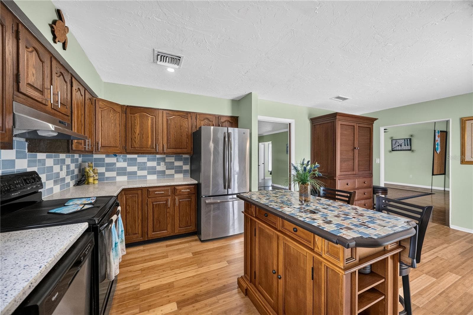 Main kitchen with abundant cabinetry and workspace. - 1305 GREENFIELD CIR, VENICE
