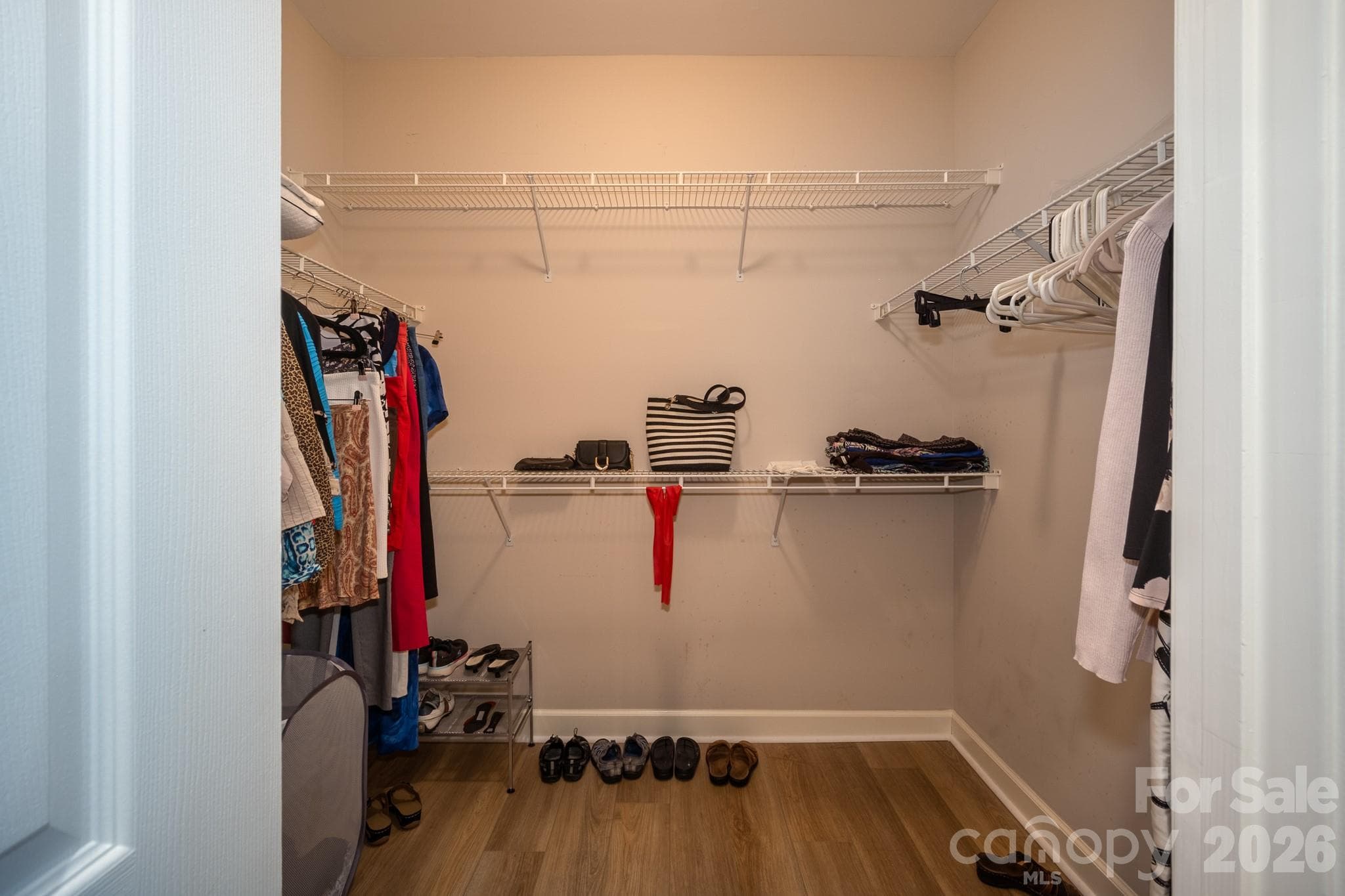 The oversized walk-in closet offers an abundance of storage with wraparound shelving, multiple hanging sections, and convenient space for shoes, handbags, and folded clothing. Its thoughtful layout keeps everything organized while providing plenty of room for seasonal wardrobes and everyday essentials. - 99 Ridgetop Circle, Brevard