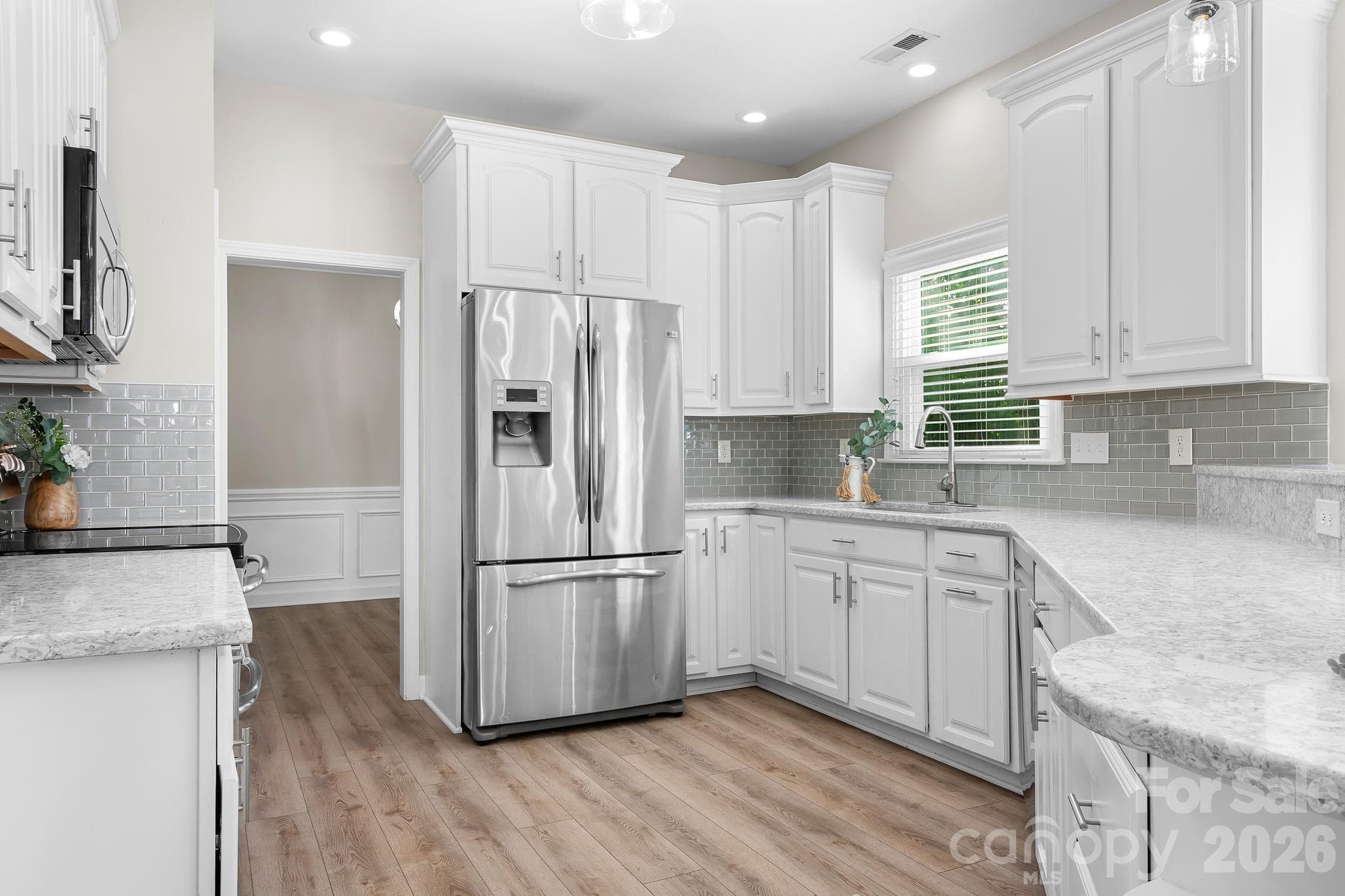Kitchen with Quartz Counters, Large Breakfast Bar area, Tons of Cabinets, Pantry, Built in Microwave, Refrigerator and Double oven.  Recessed Dimmer Lights, LVP Flooring, and Open to Family Room - Cornelius