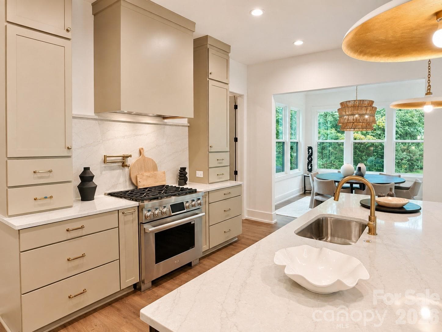 The gourmet kitchen is equipped with LG SKS appliances, Quartz countertop and backsplash at range hood, pot filler. - Charlotte