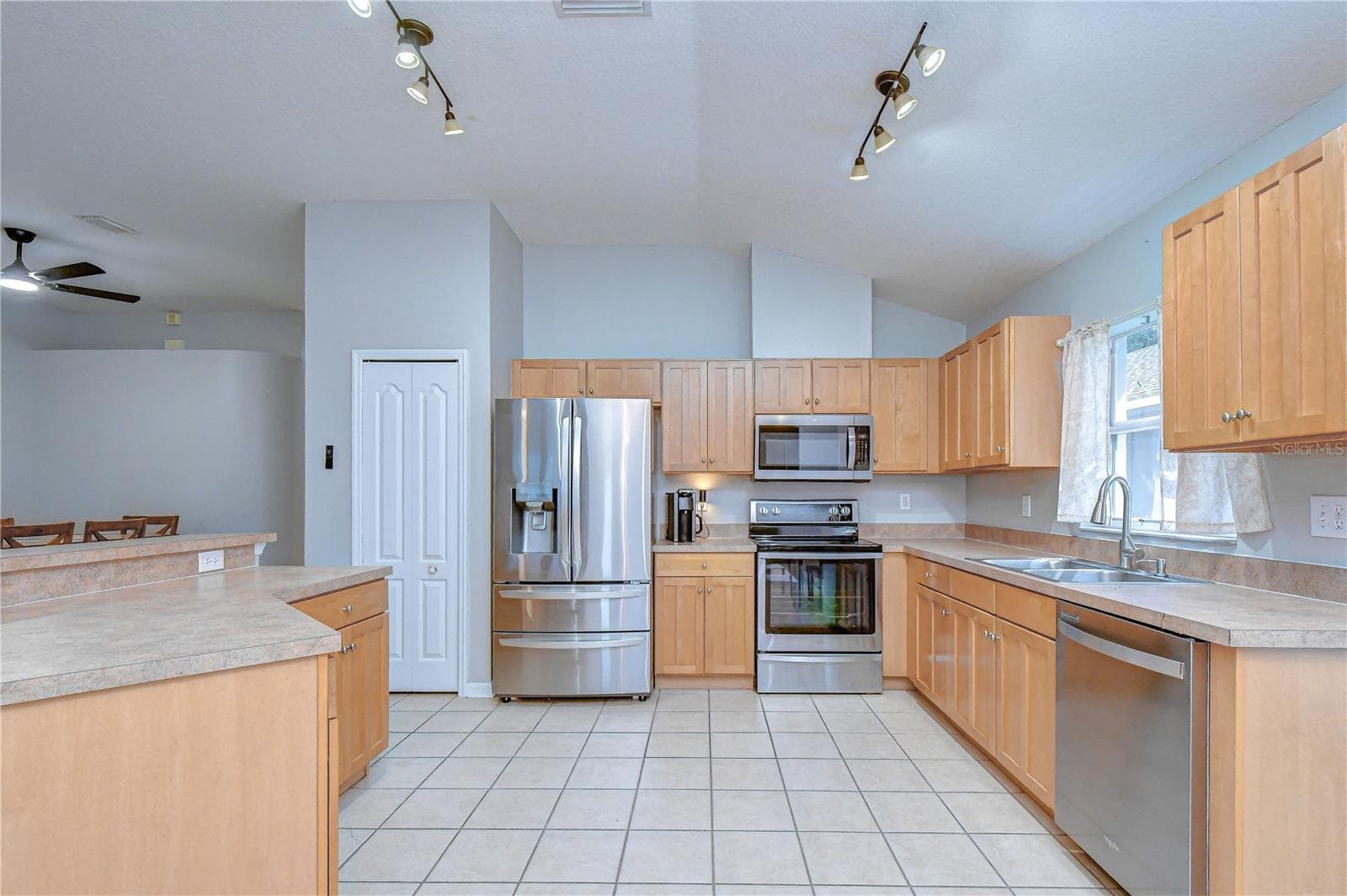 Functional kitchen featuring generous cabinetry, workspace, and an open connection to the main living areas. - 11117 RODEO LN, RIVERVIEW