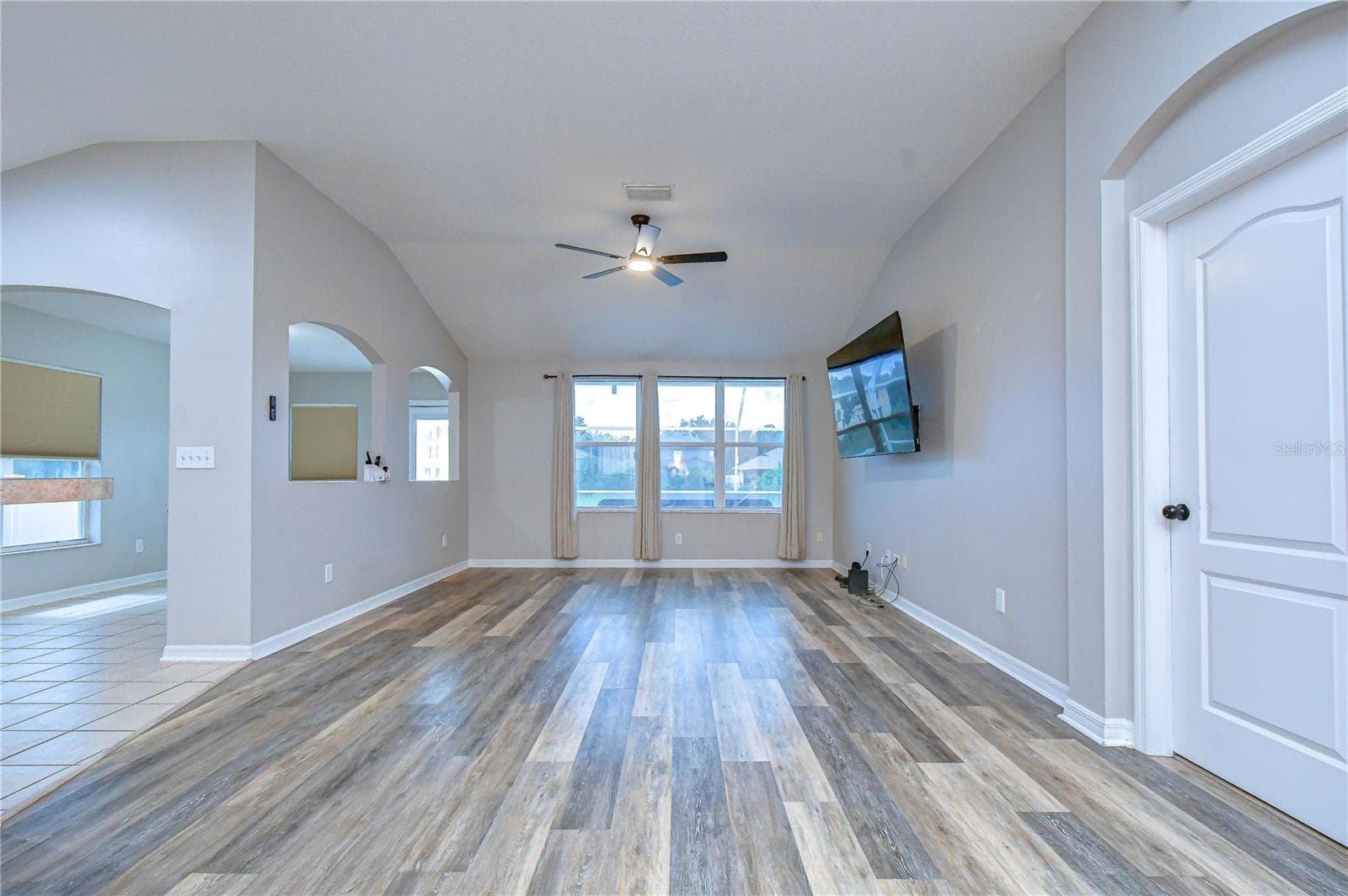Bright gathering space featuring soaring vaulted ceilings and durable luxury vinyl flooring throughout. - 11117 RODEO LN, RIVERVIEW
