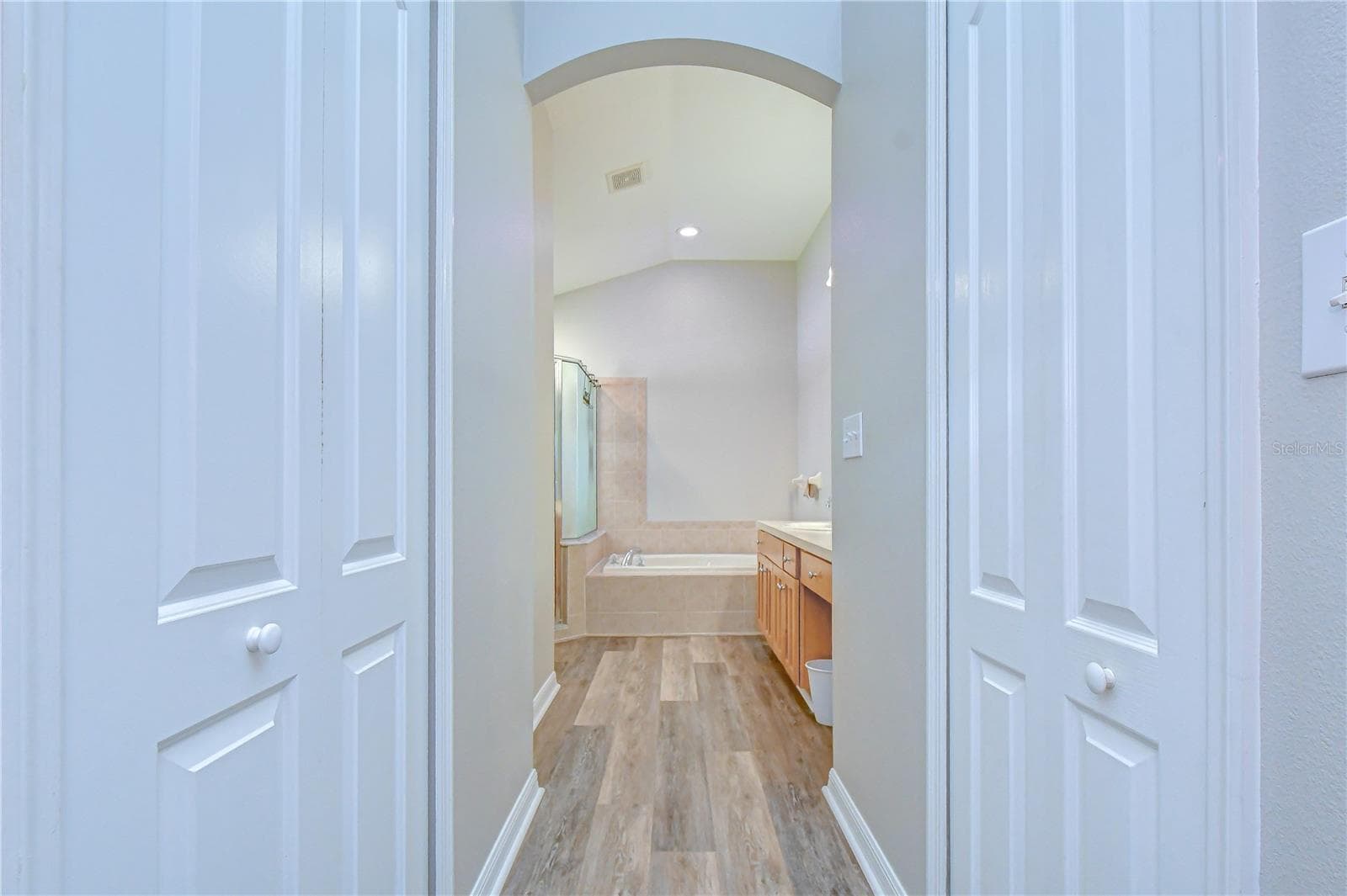 Architectural hallway highlight featuring durable wood-look floors, detailed trim, and an inviting double-door entrance. - 11117 RODEO LN, RIVERVIEW