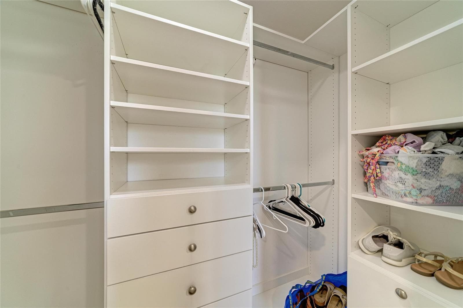 Primary bedroom walk-in closet with custom shelving. - 2011 37TH ST W, BRADENTON