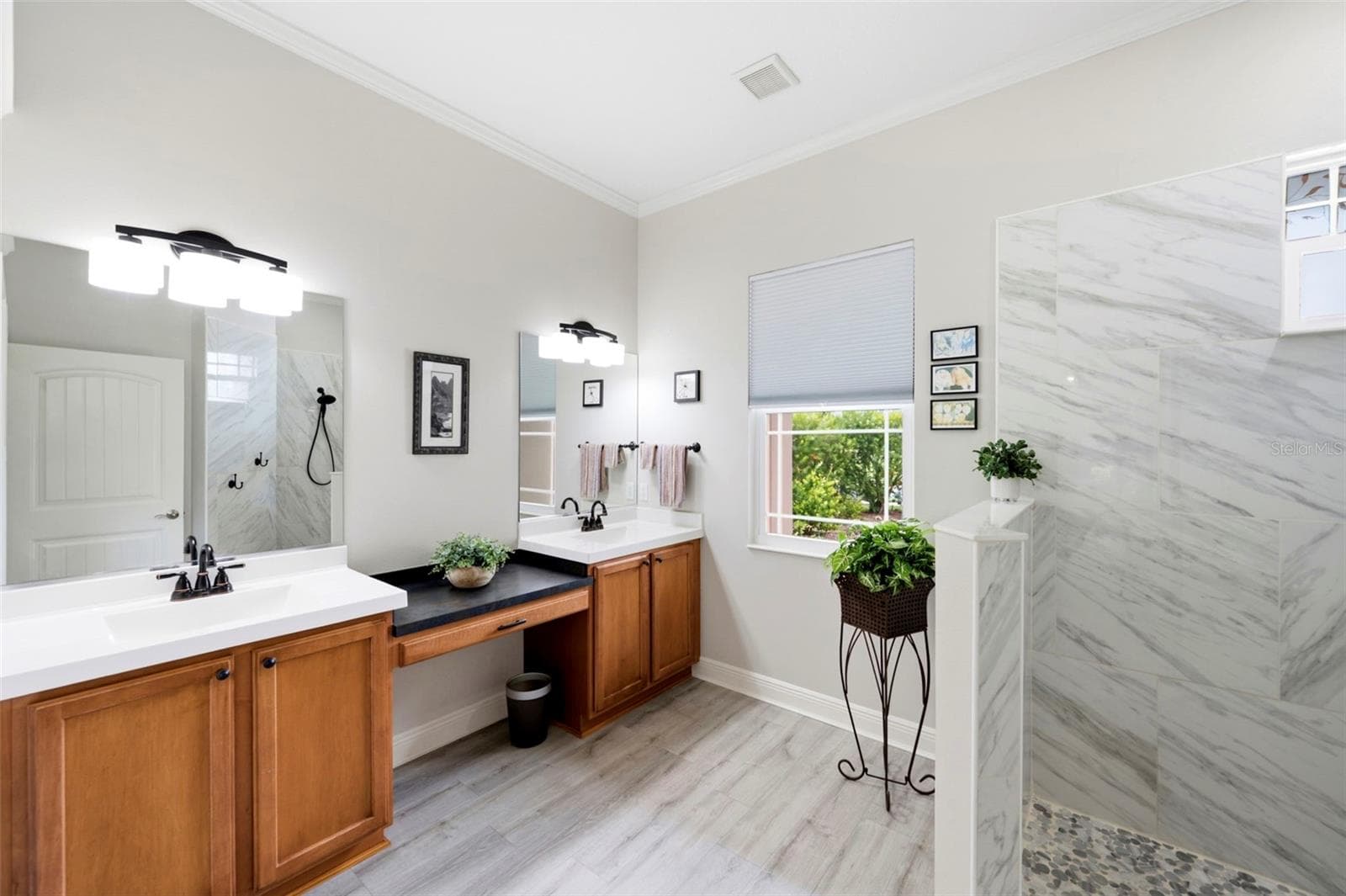 The primary bathroom feautures dual wet vanities a desk like vanity in between - 3850 CREEKSIDE PARK DR, PARRISH